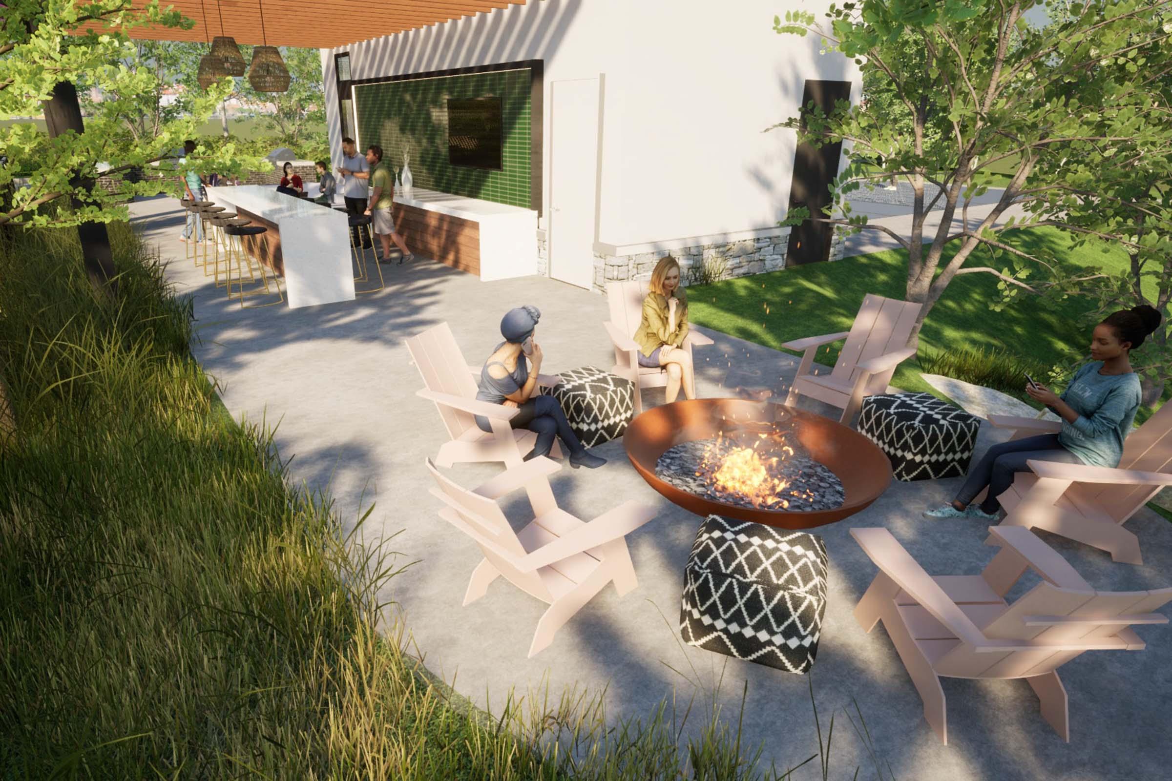 Outdoor gathering space featuring a fire pit surrounded by modern chairs and poufs. In the background, a bar area with people socializing. Lush greenery and a sleek architectural design create a cozy atmosphere for relaxation and conversation.