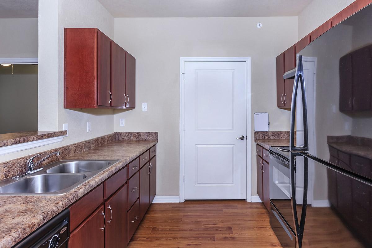 a large kitchen with stainless steel appliances and wooden cabinets