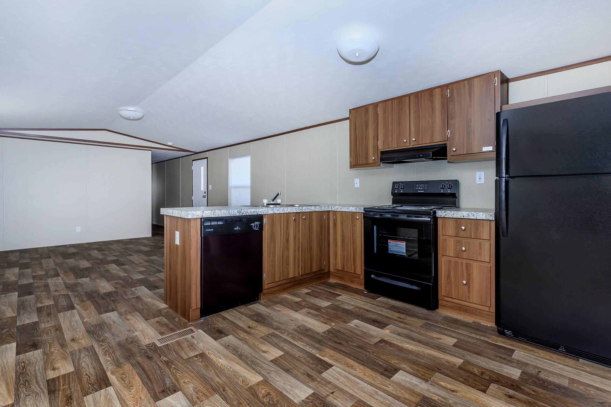 a kitchen with wooden cabinets and a wood floor