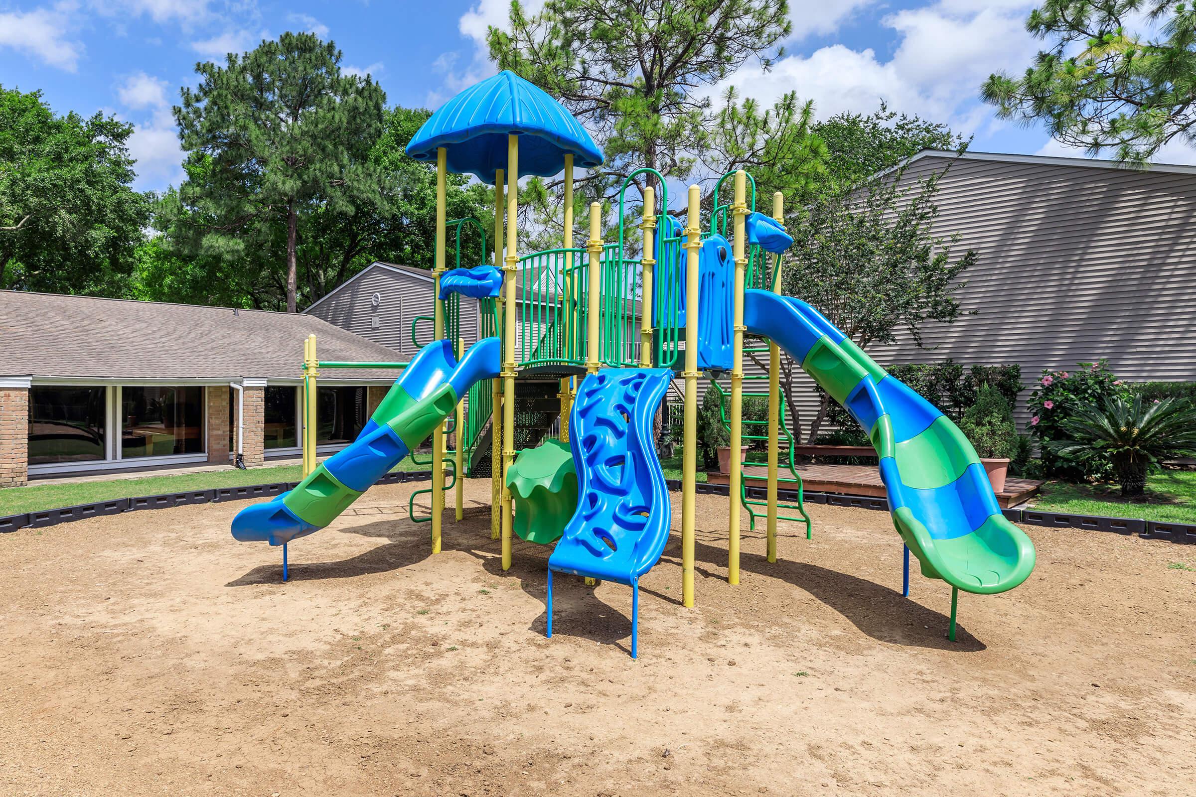 a playground with a blue umbrella