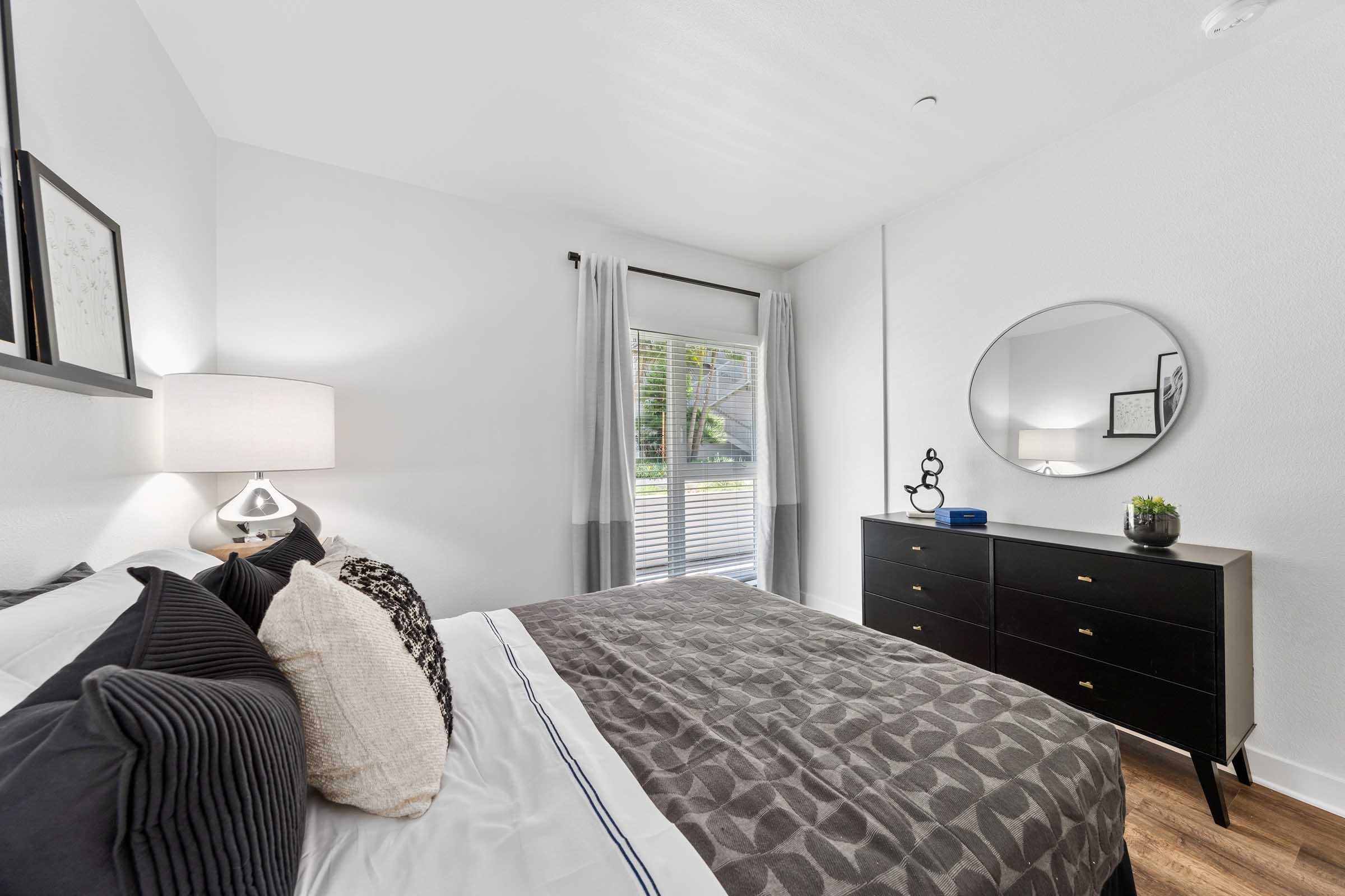 a bedroom with a mirror and dresser