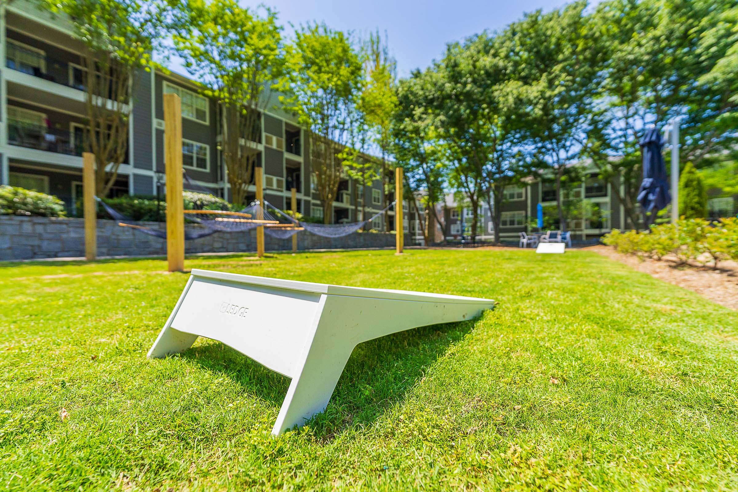 a couple of lawn chairs sitting on top of a grass covered field