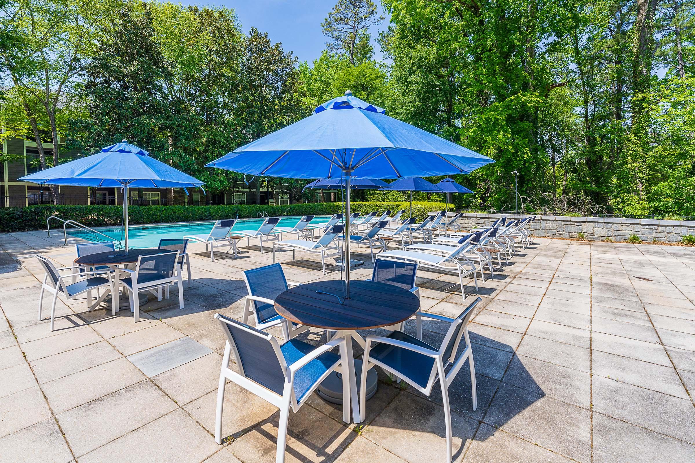 a group of lawn chairs sitting on a table with a blue umbrella