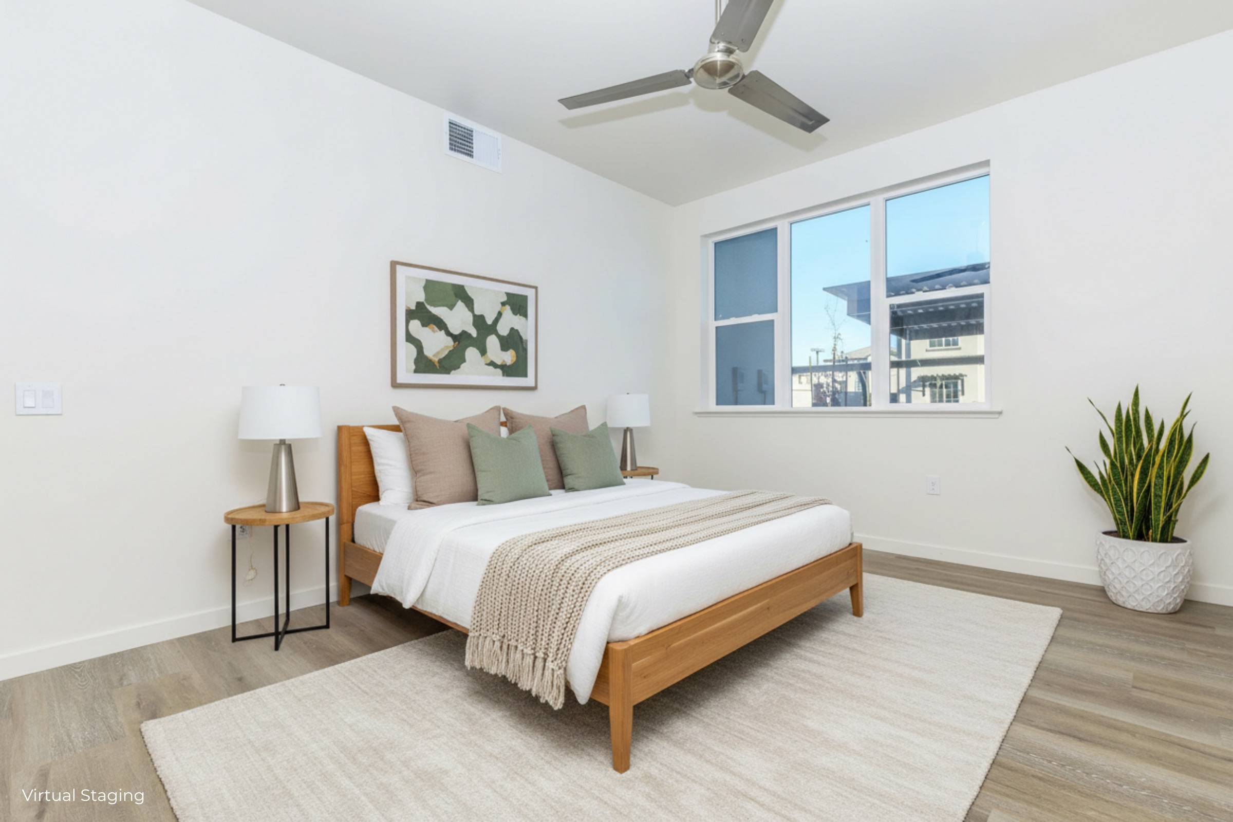 A modern, minimalist bedroom featuring a wooden bed with neutral bedding and decorative pillows. Two bedside lamps flank the bed, and a large window provides natural light, offering a view of an outdoor space. A potted plant adds a touch of greenery, complementing the serene atmosphere.