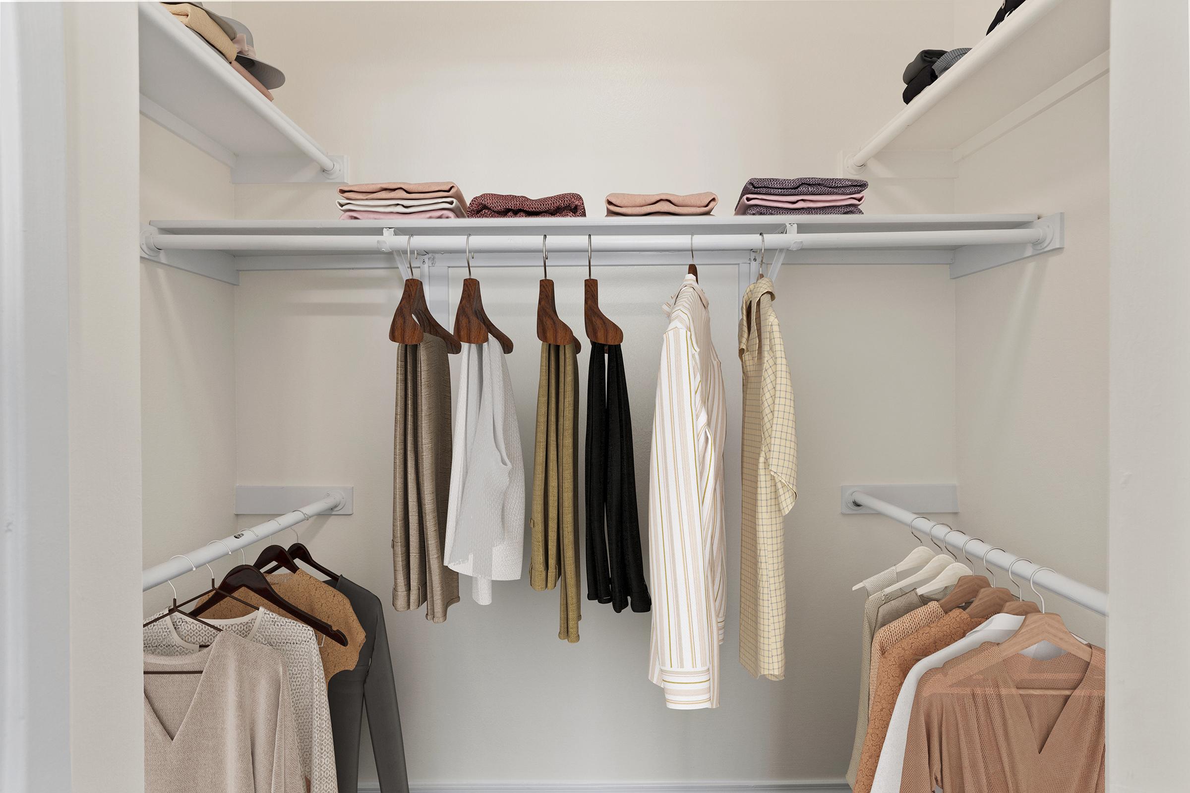 A neatly organized closet featuring shelves with folded clothes and a clothing rod displaying a variety of hanging garments. The colors include beige, white, and muted tones, highlighting a minimalist and tidy aesthetic.
