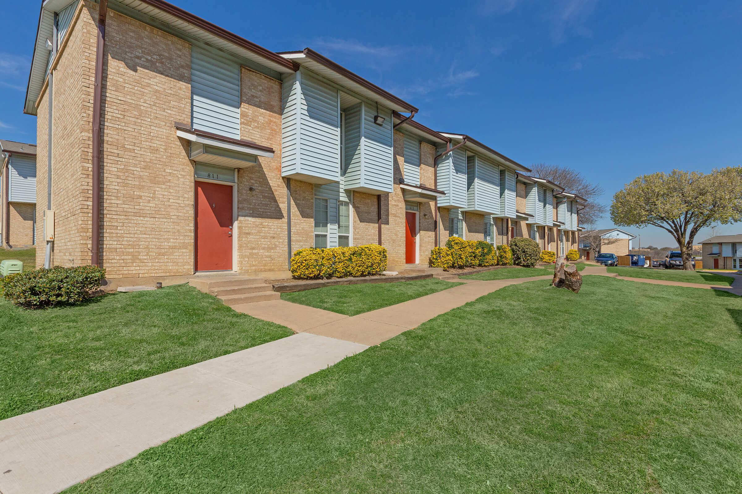 a large lawn in front of a brick building