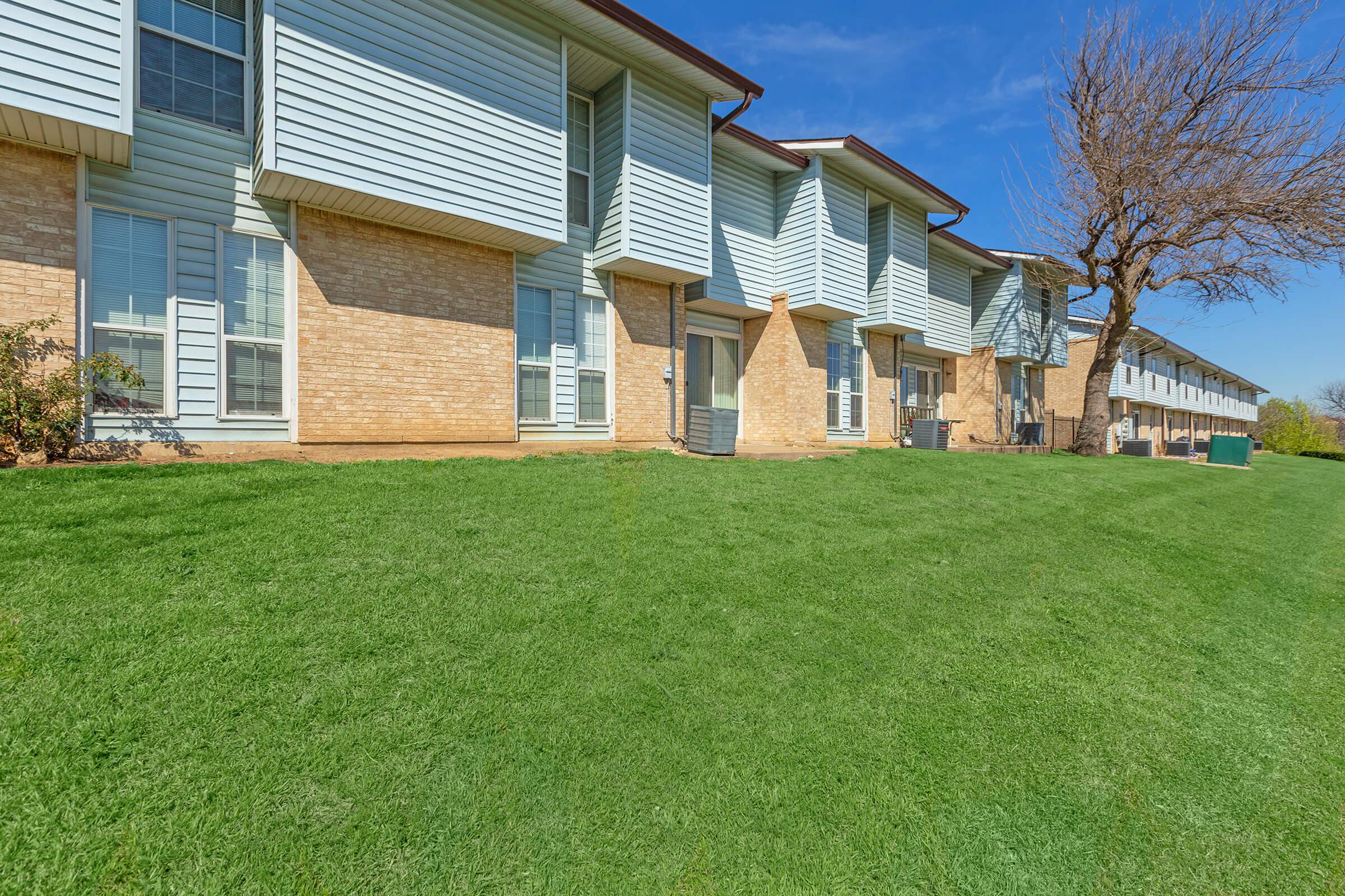 a large green field in front of a house