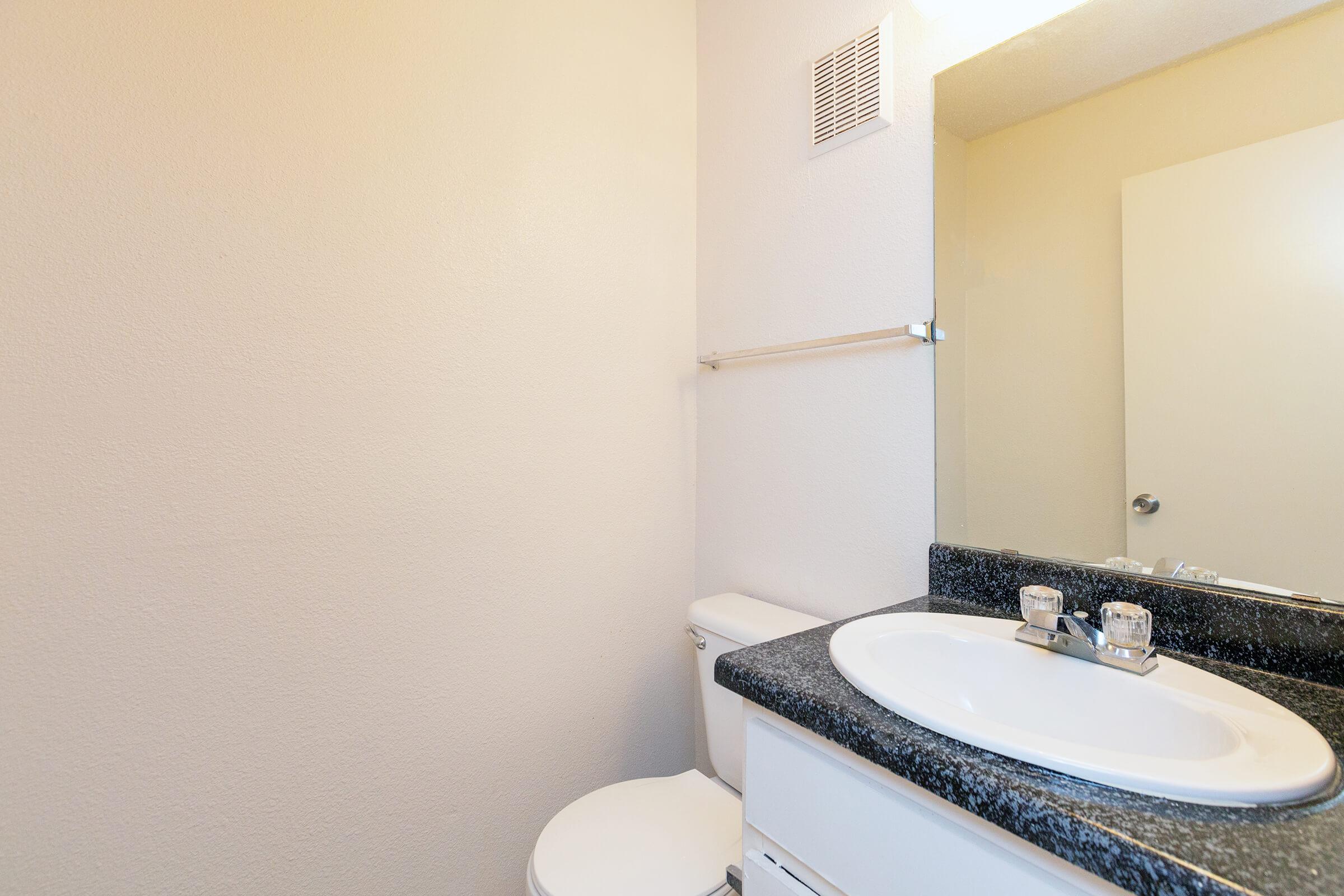 a white sink sitting under a mirror