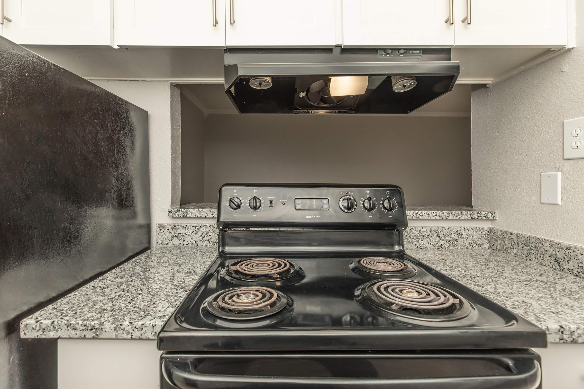 a stove top oven sitting inside of a kitchen