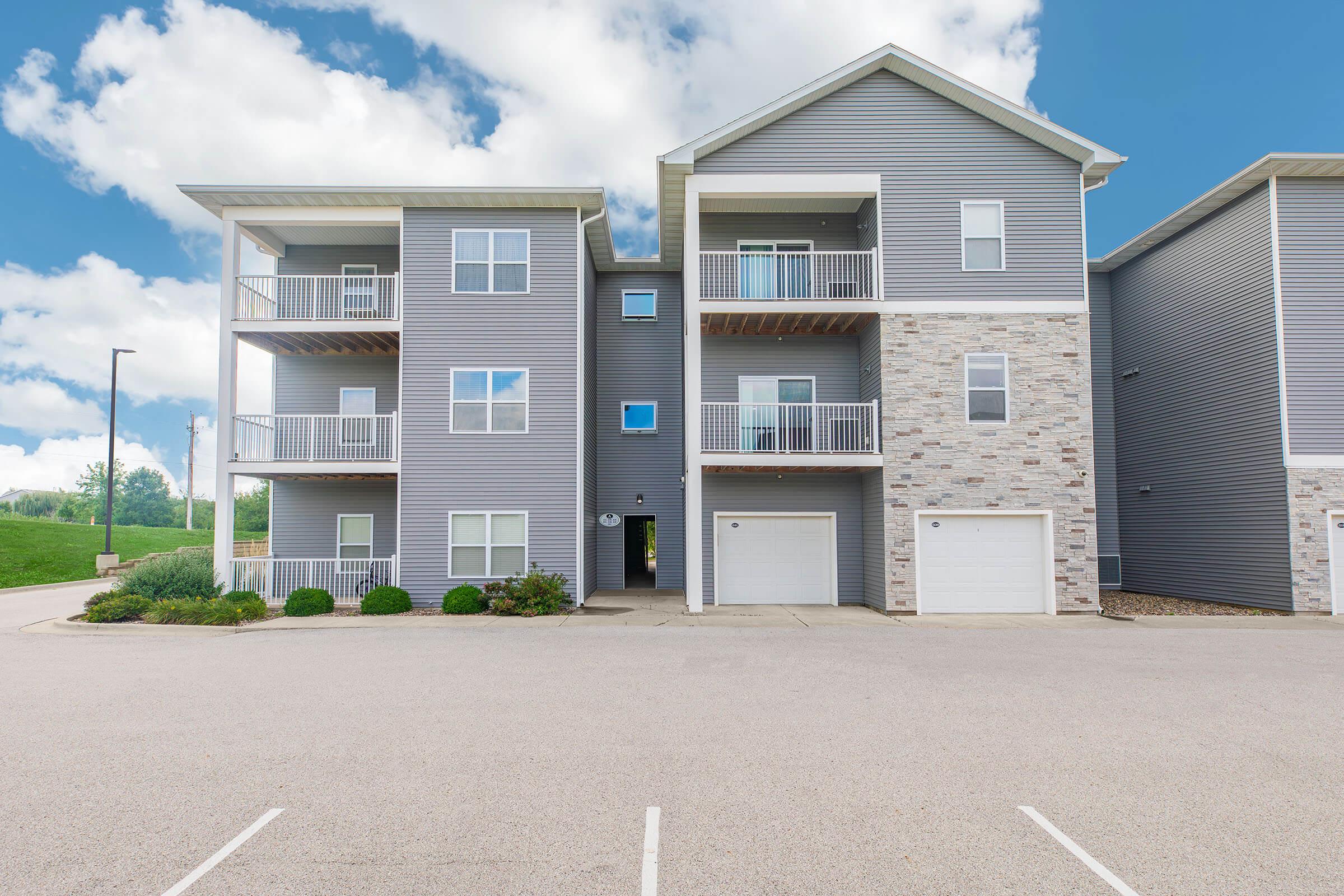 Exterior view of apartments with stone accents at The Groves on Devils Glen in Bettendorf, IA