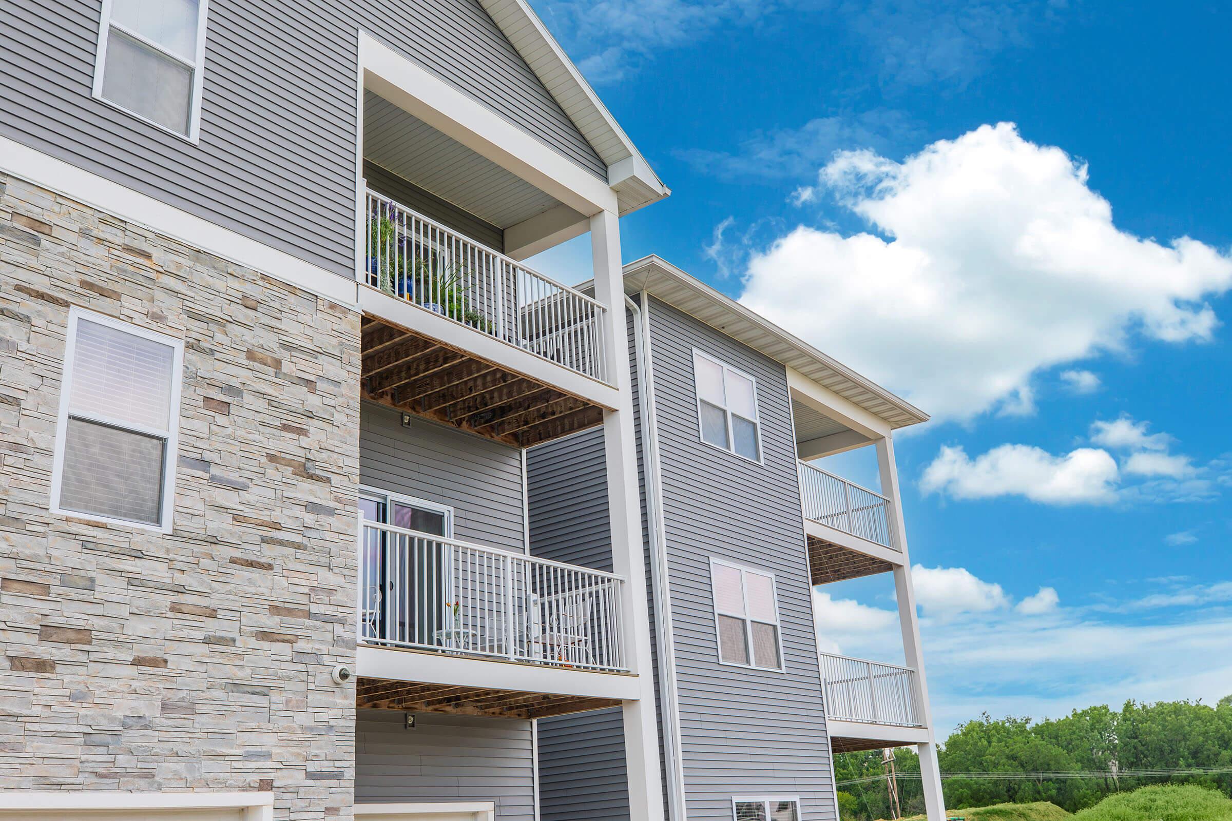 Close-up of balconies and stone siding on new apartments at The Groves on Devils Glen in Bettendorf, IA