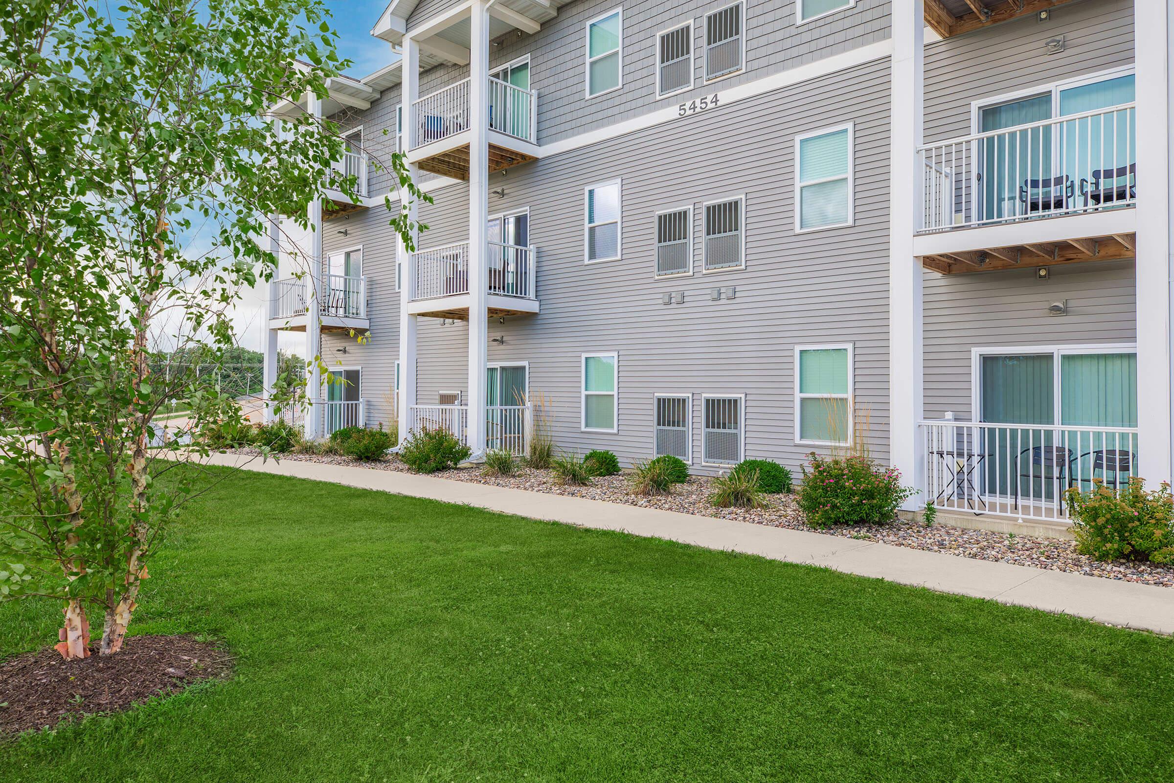 Courtyard lawn area beside apartments at The Groves on Devils Glen in Bettendorf, IA
