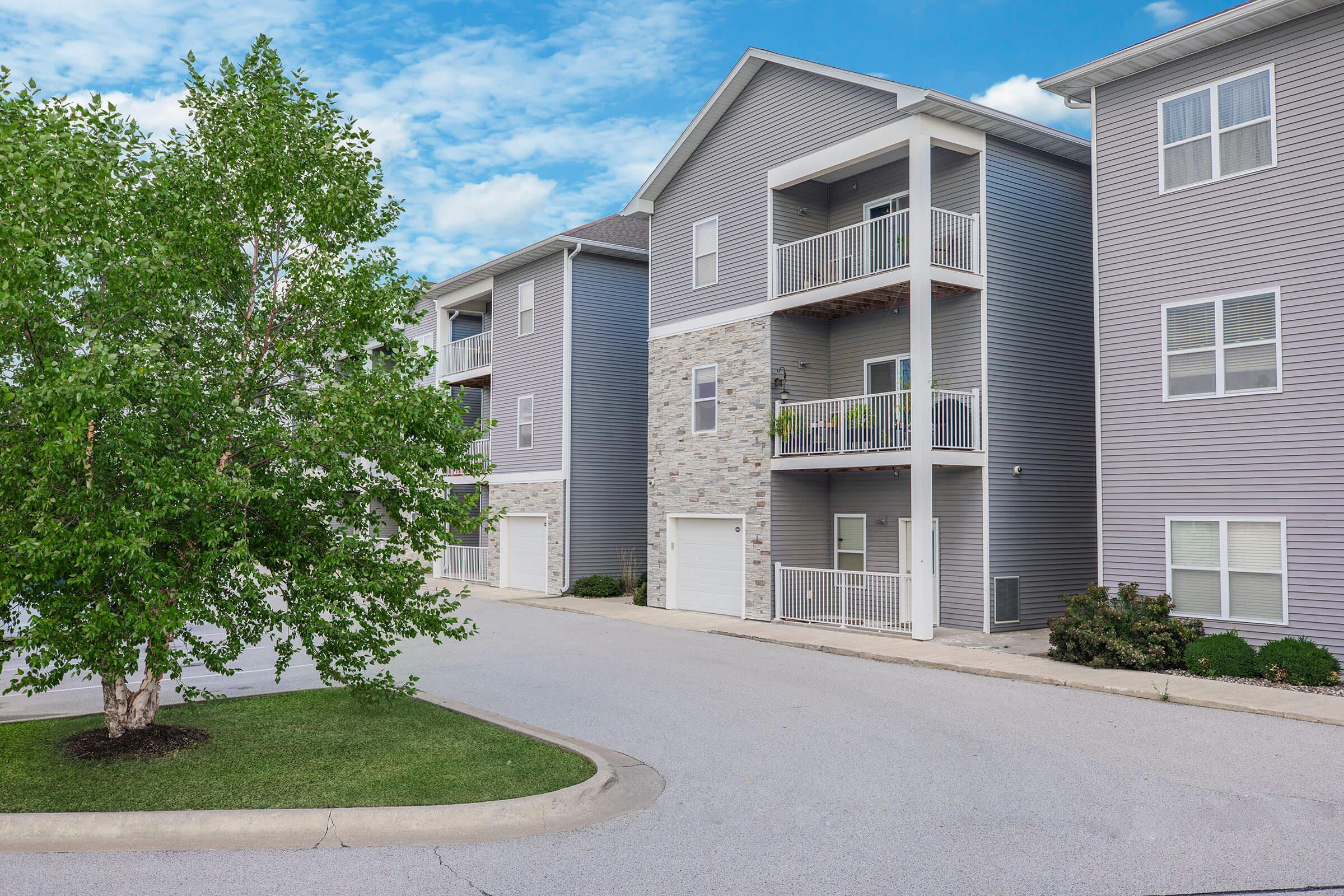 Driveway and building entrance with balconies at The Groves on Devils Glen in Bettendorf, IA