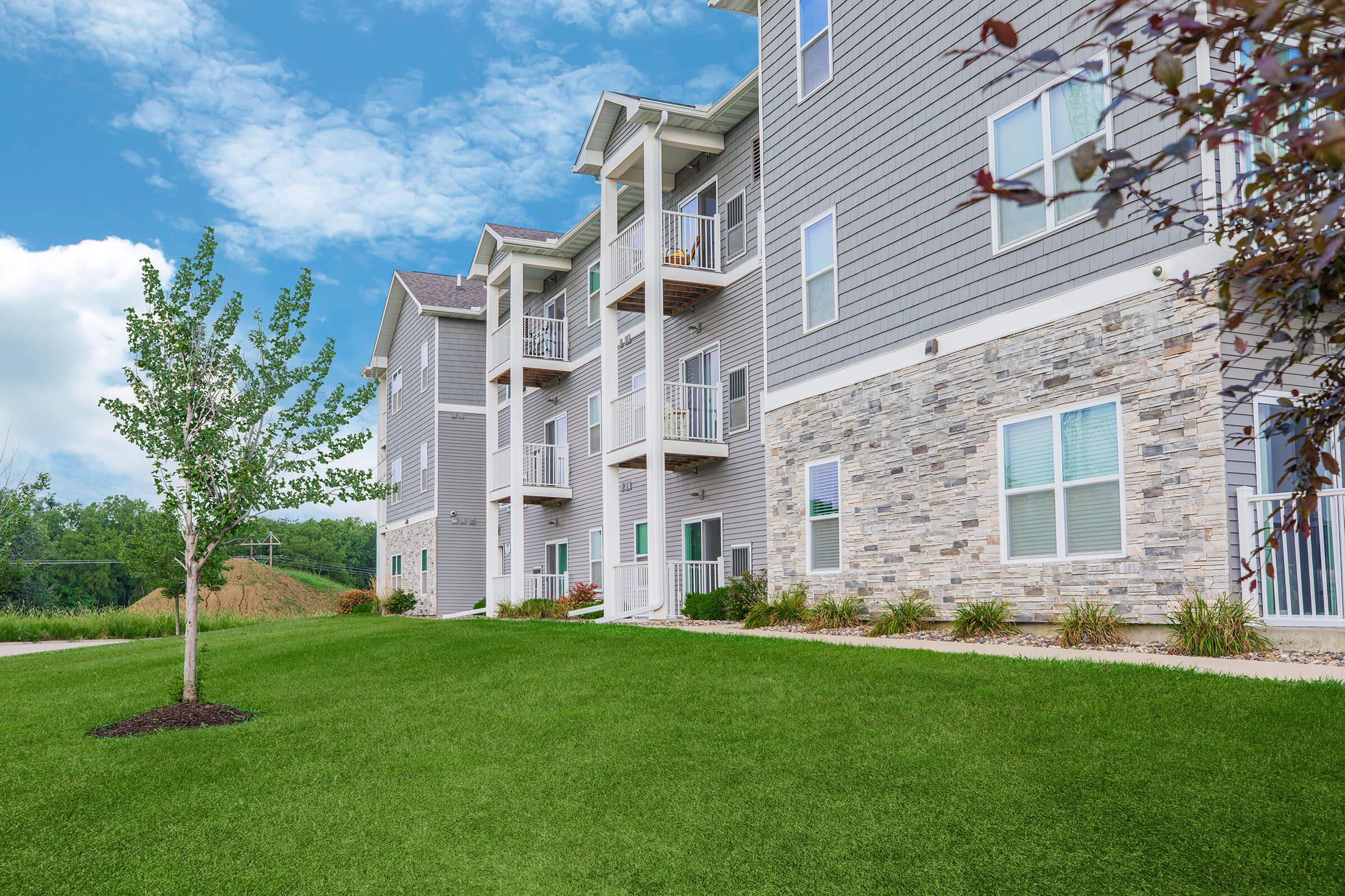Walkway and landscaped exterior of new apartments at The Groves on Devils Glen in Bettendorf, IA