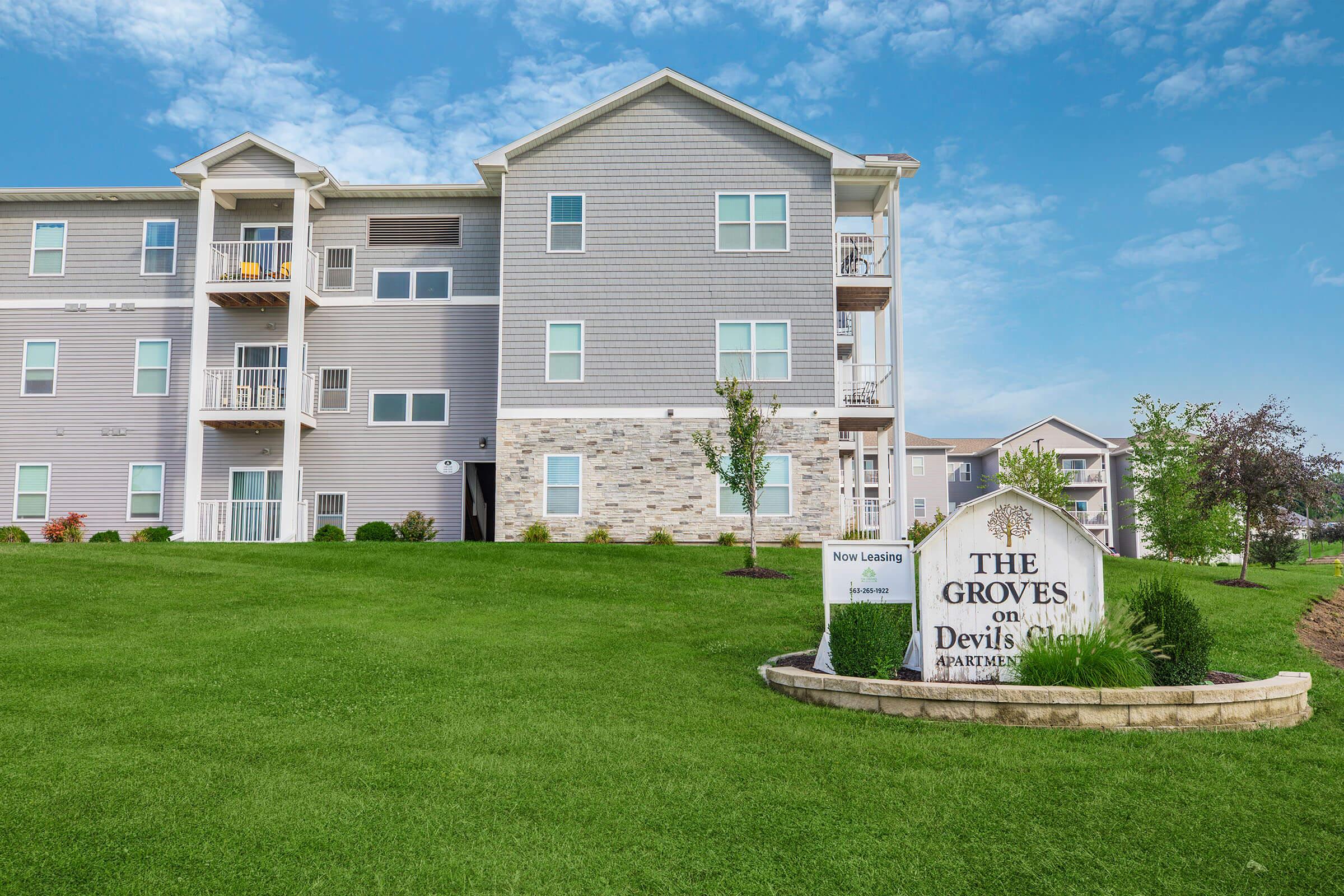 Community sign and landscaped entrance at The Groves on Devils Glen apartments in Bettendorf, IA Pleasant Valley School District
