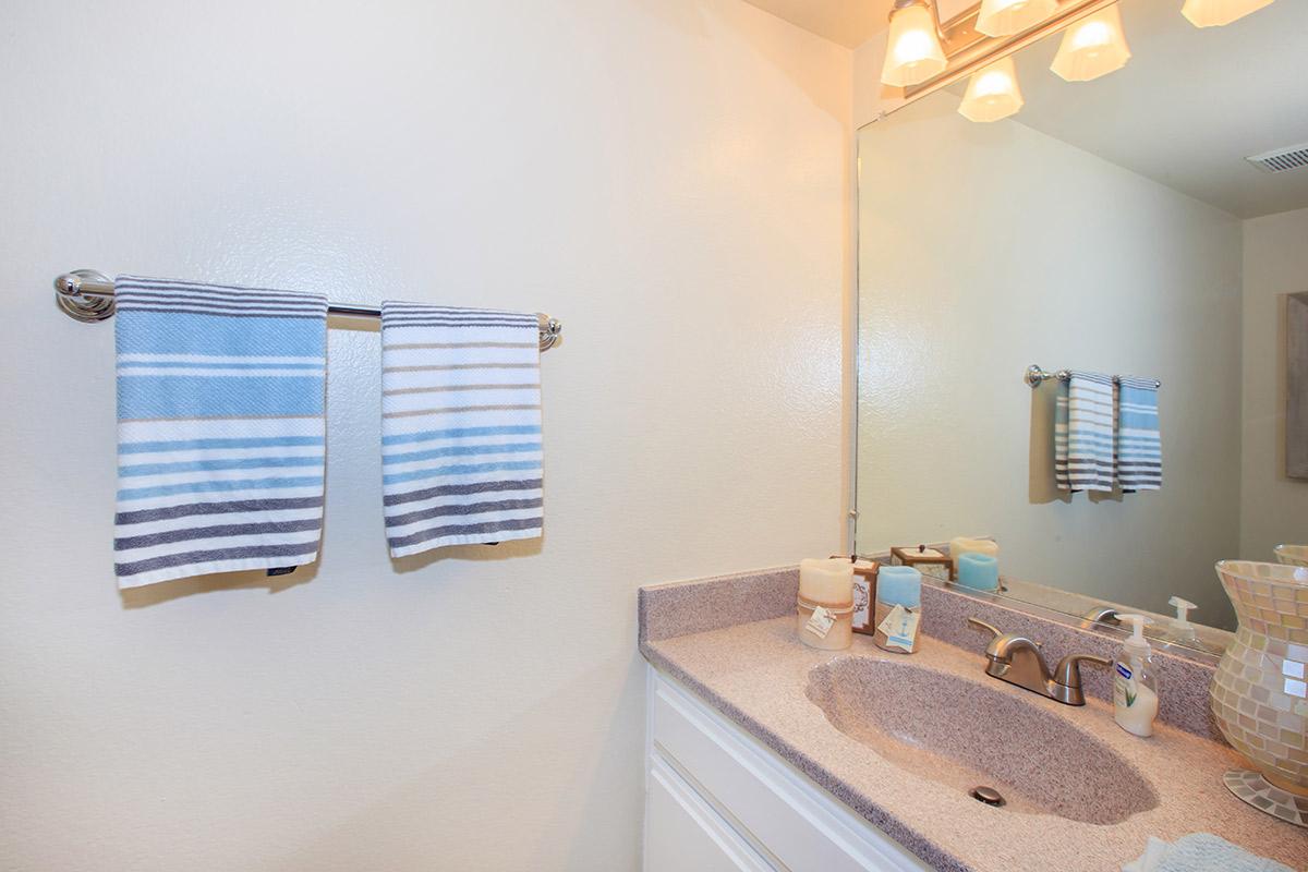 a bedroom area with a sink and a mirror