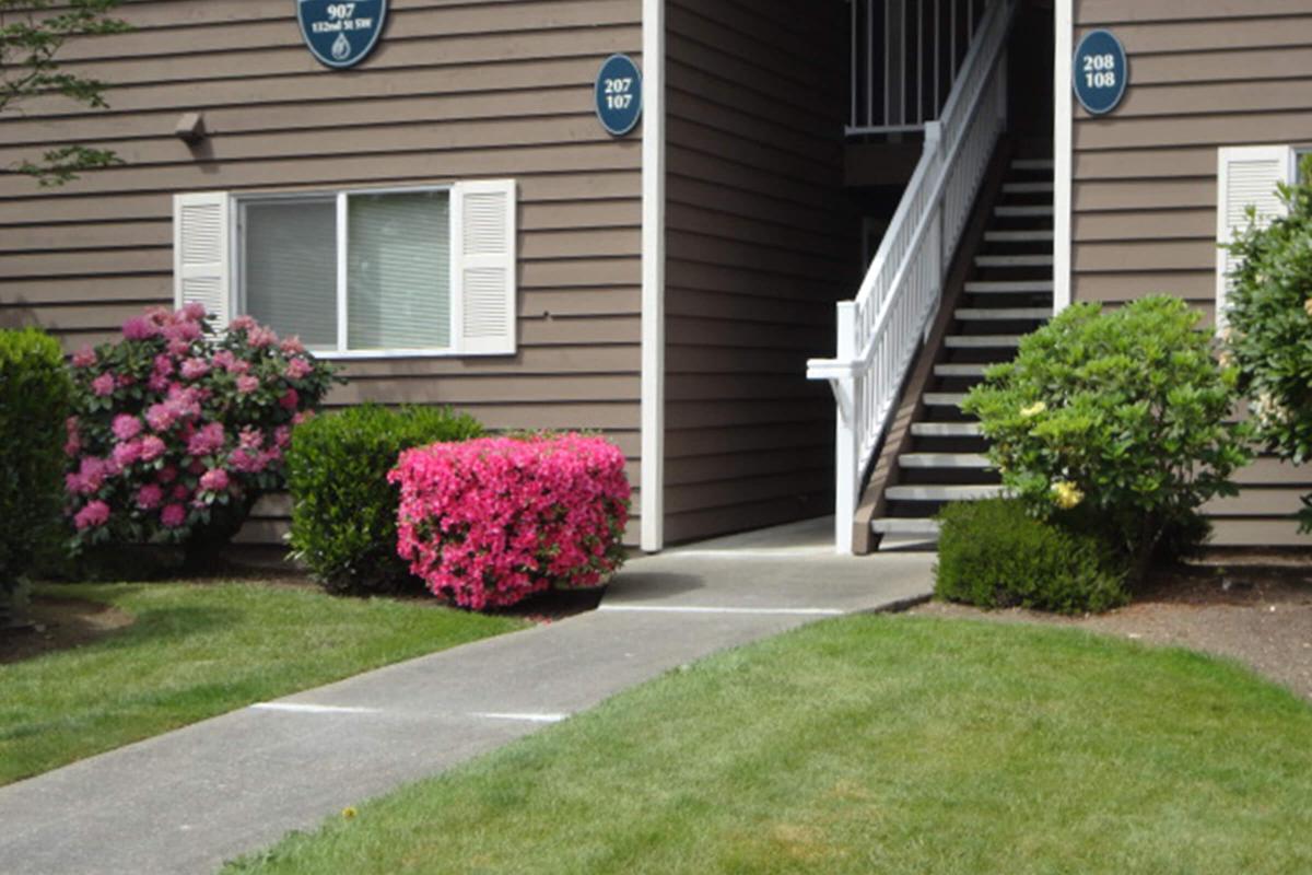 a close up of a flower garden in front of a house