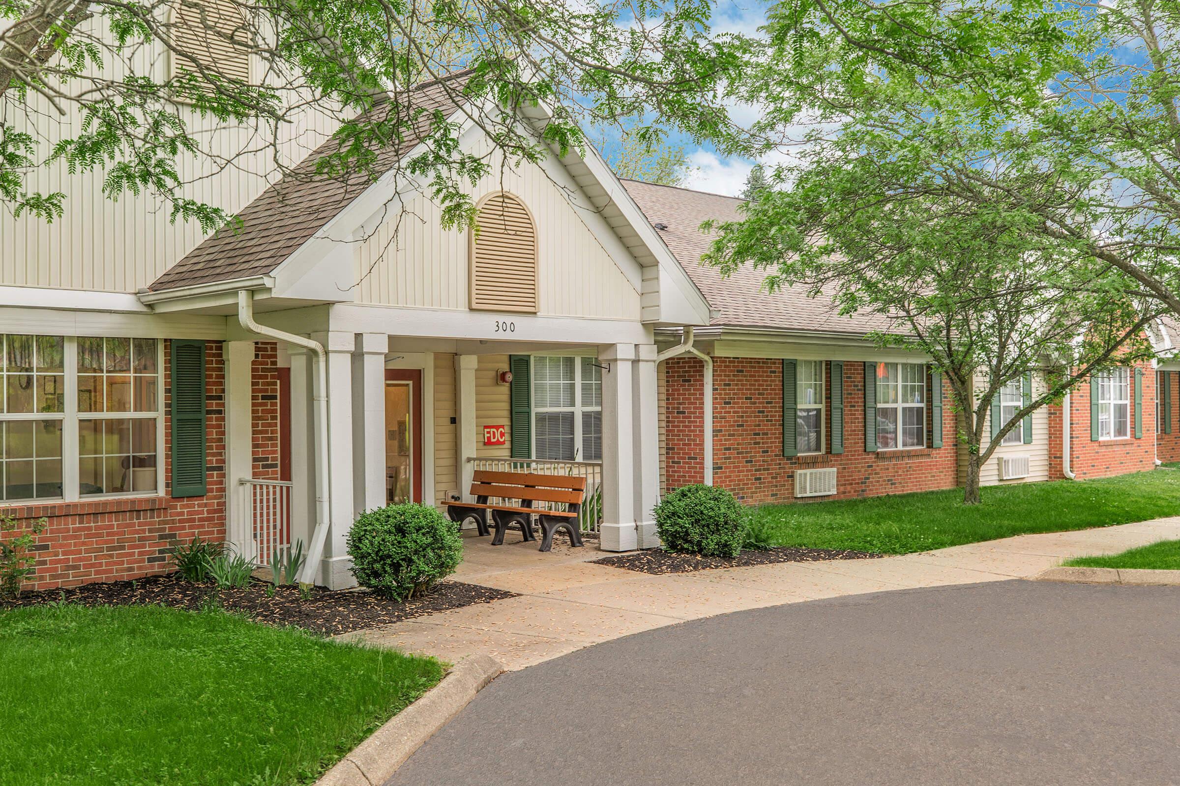 a house with bushes in front of a brick building