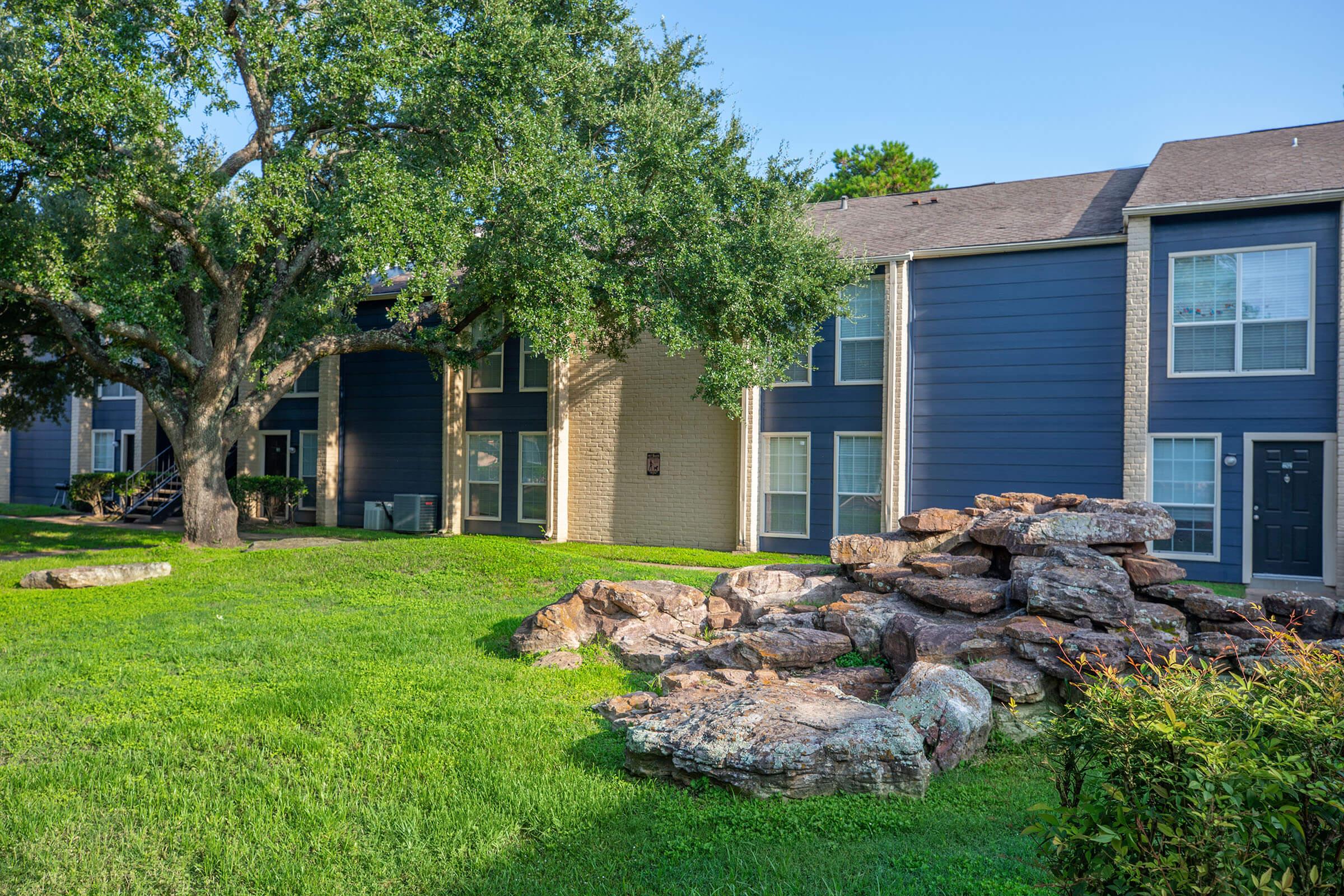 a large brick building with grass in front of a house