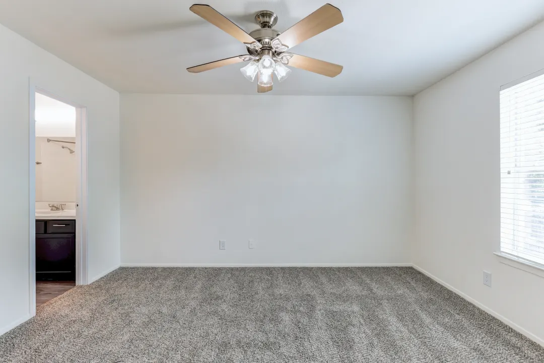 a bedroom with a ceiling fan in a room