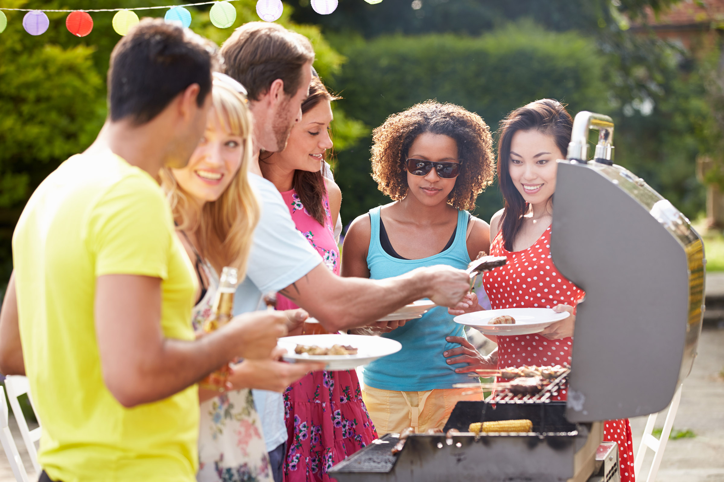 a group of people looking at a birthday cake