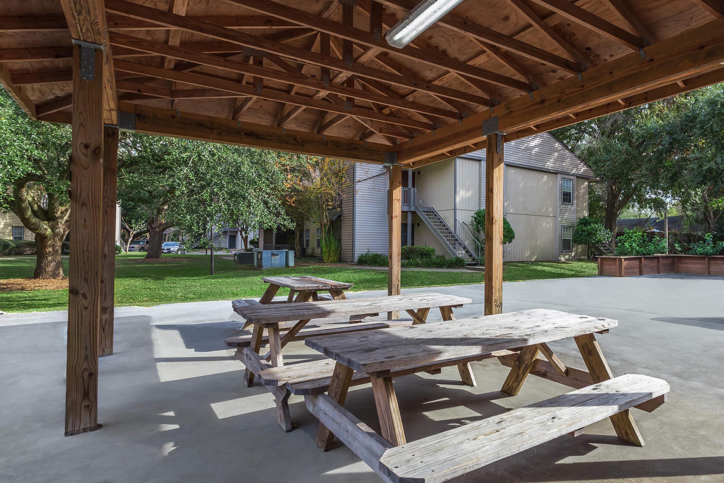 an empty park bench next to a picnic table