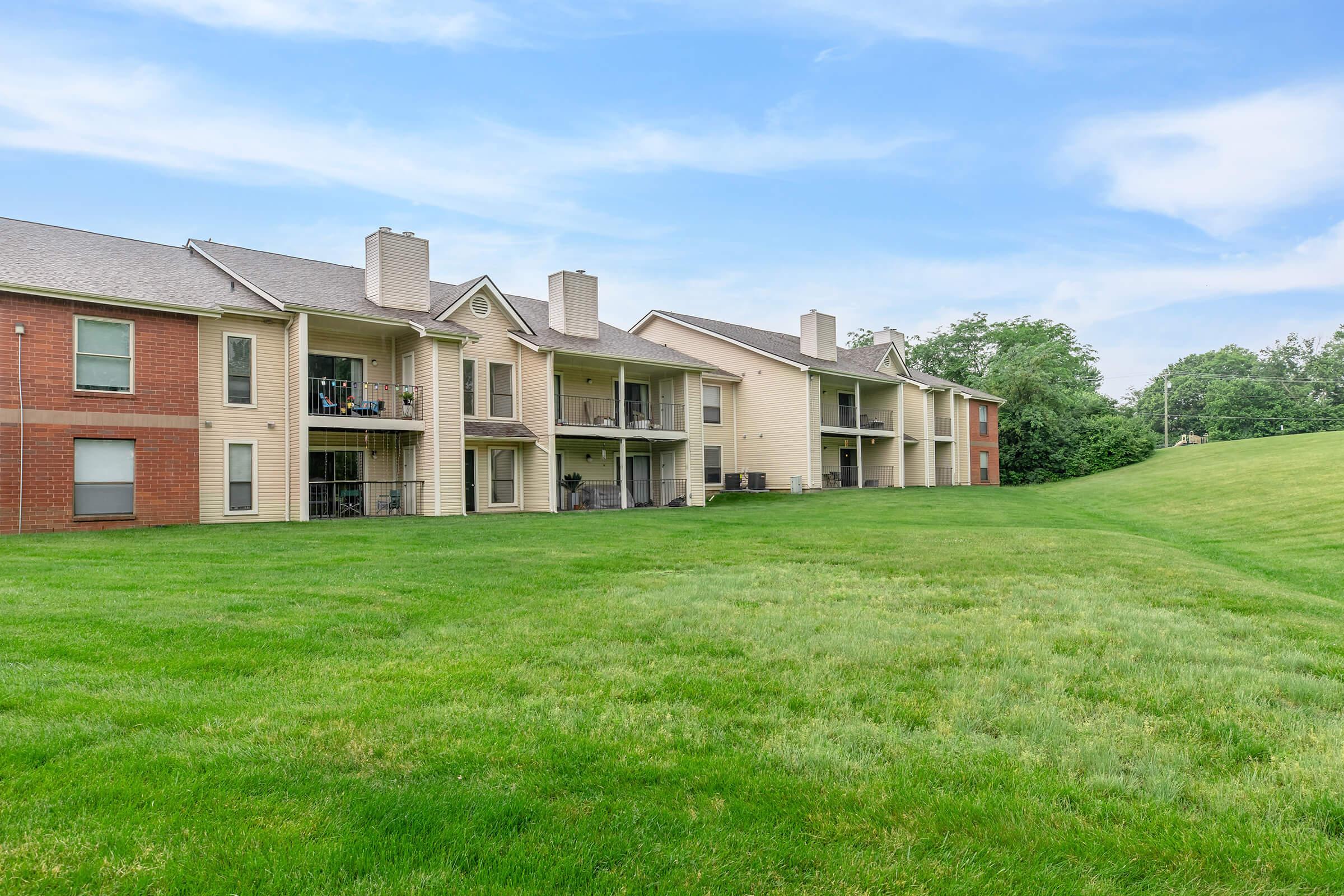 a large green field in front of a house