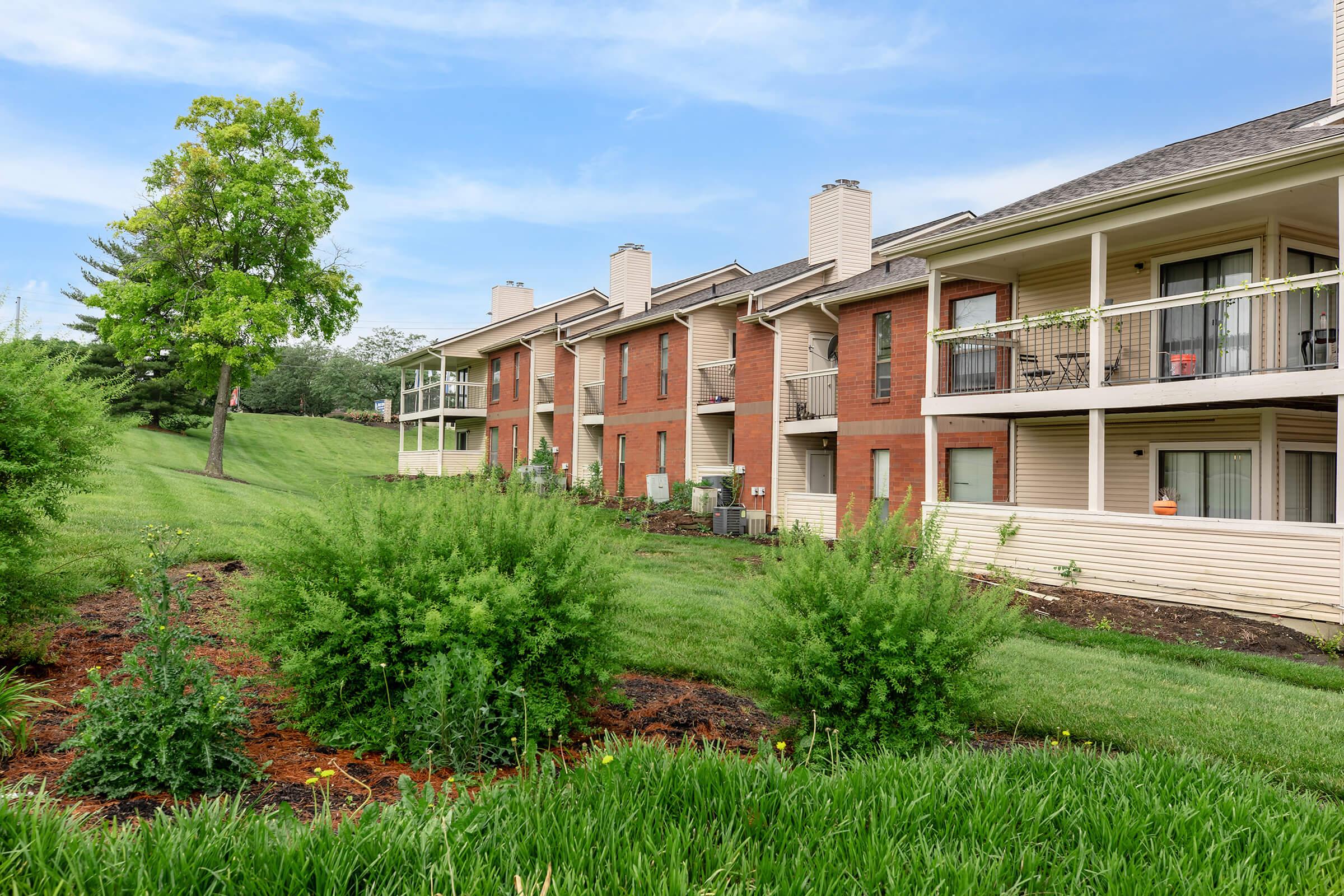 a large brick building with grass in front of a house