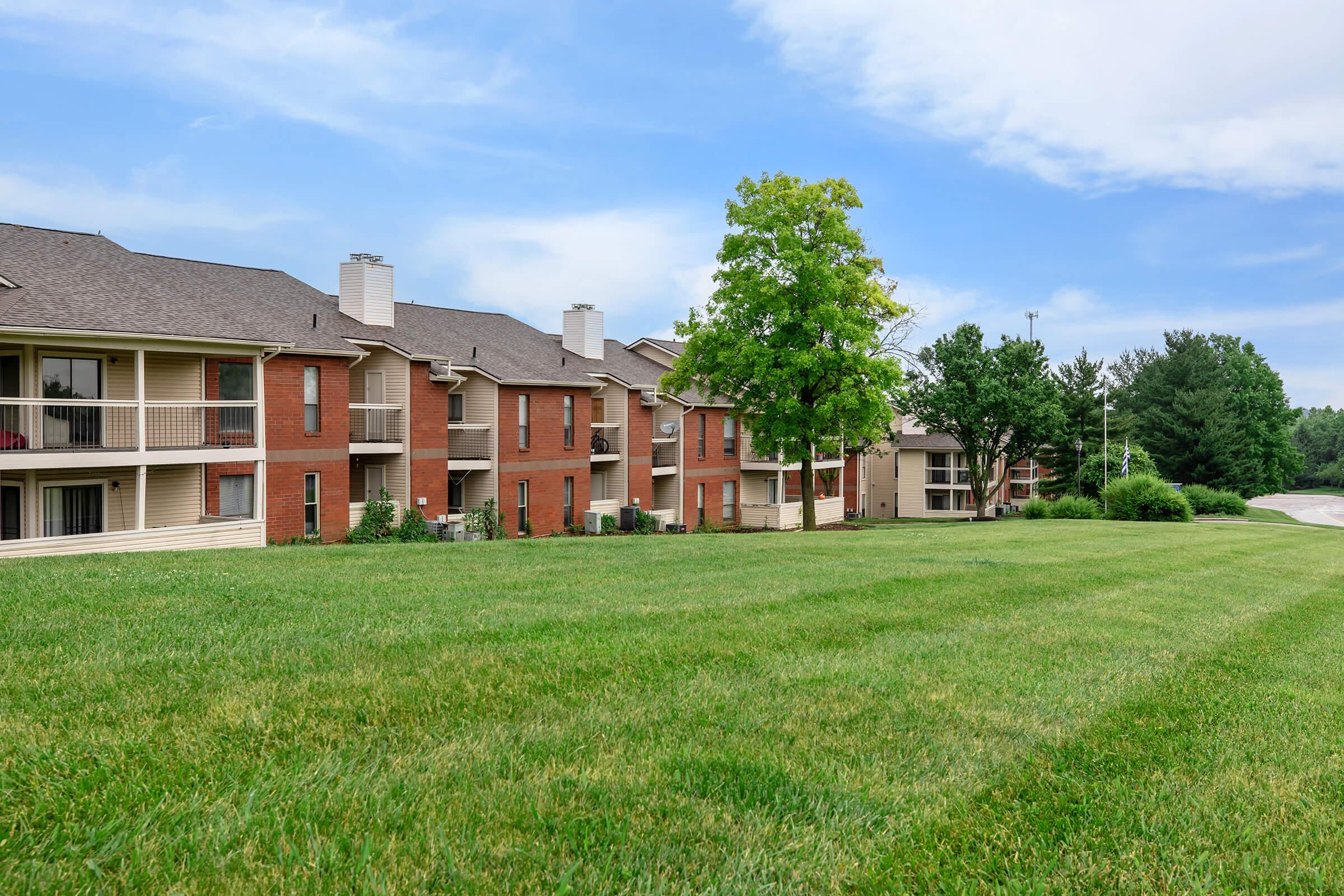 a large green field in front of a house