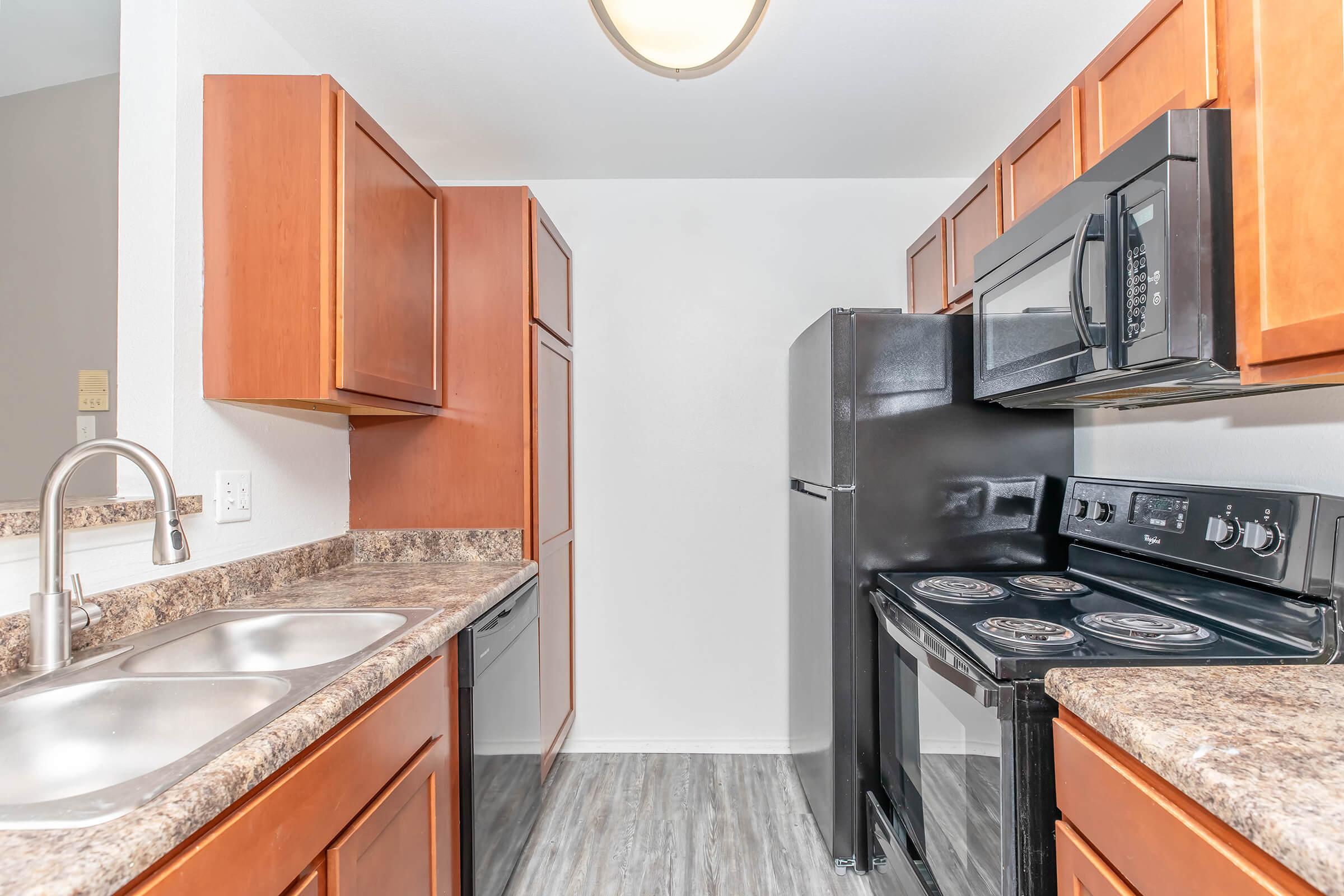 a modern kitchen with stainless steel appliances and wooden cabinets