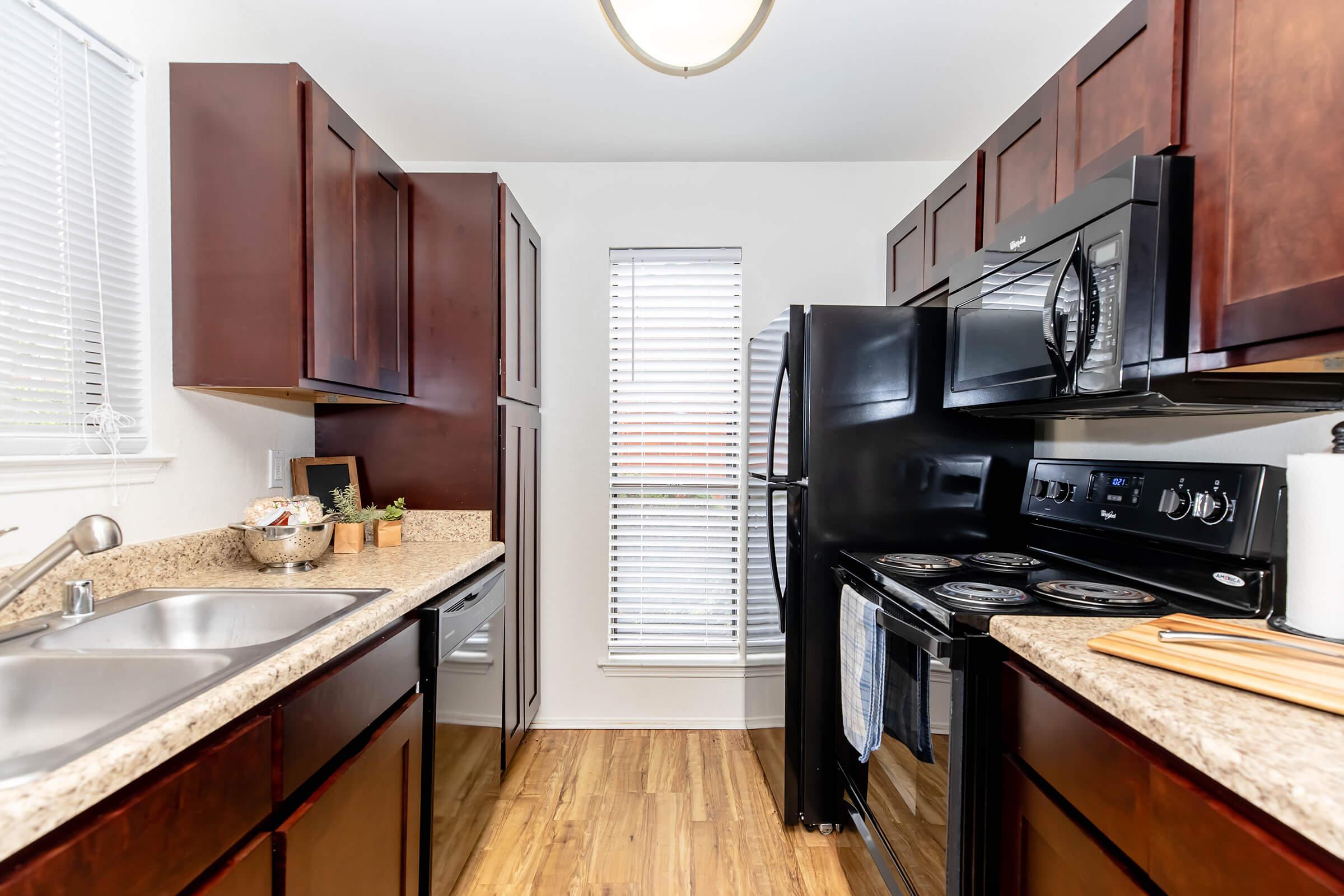 a modern kitchen with stainless steel appliances and wooden cabinets