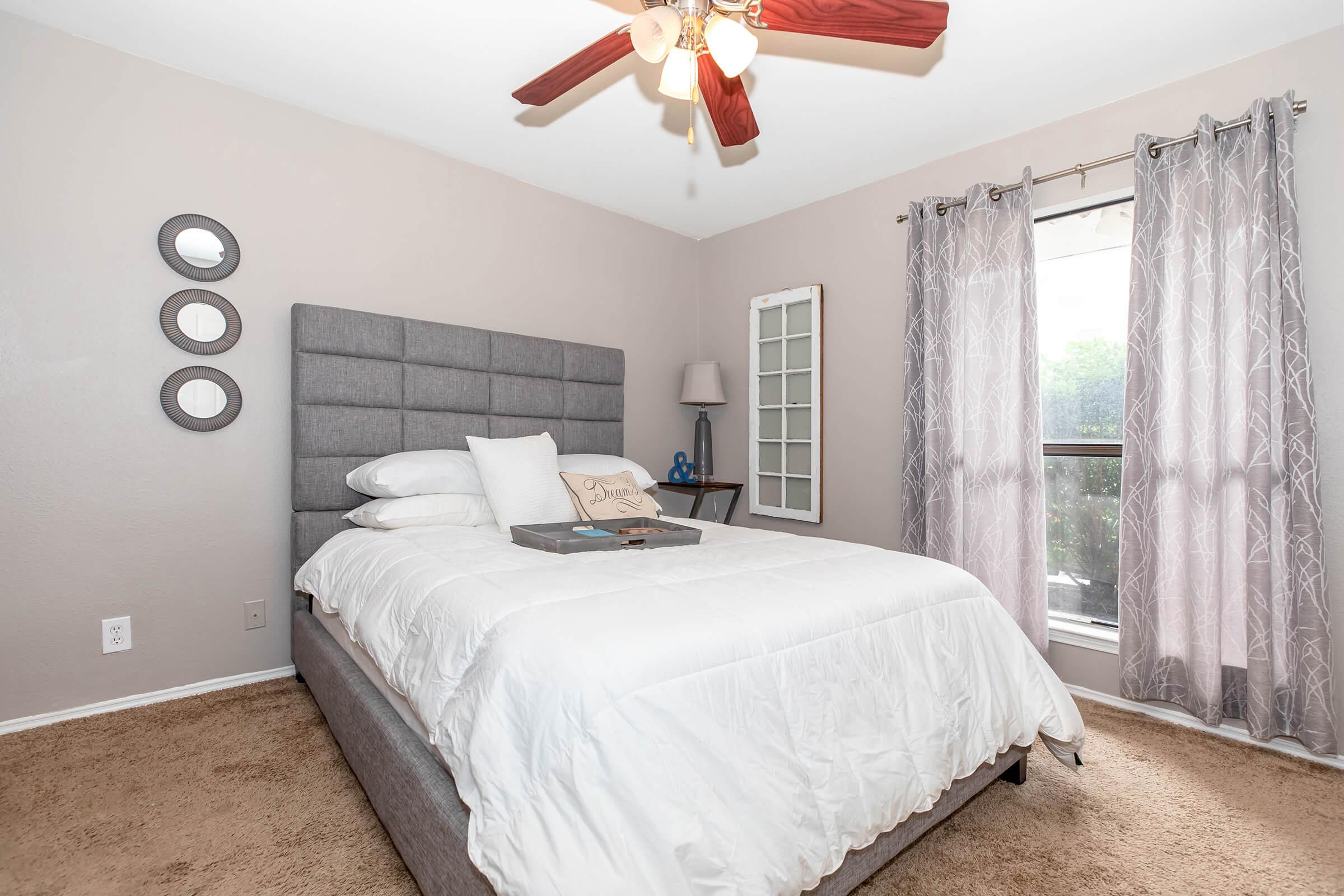 a bedroom with a bed and desk in a room