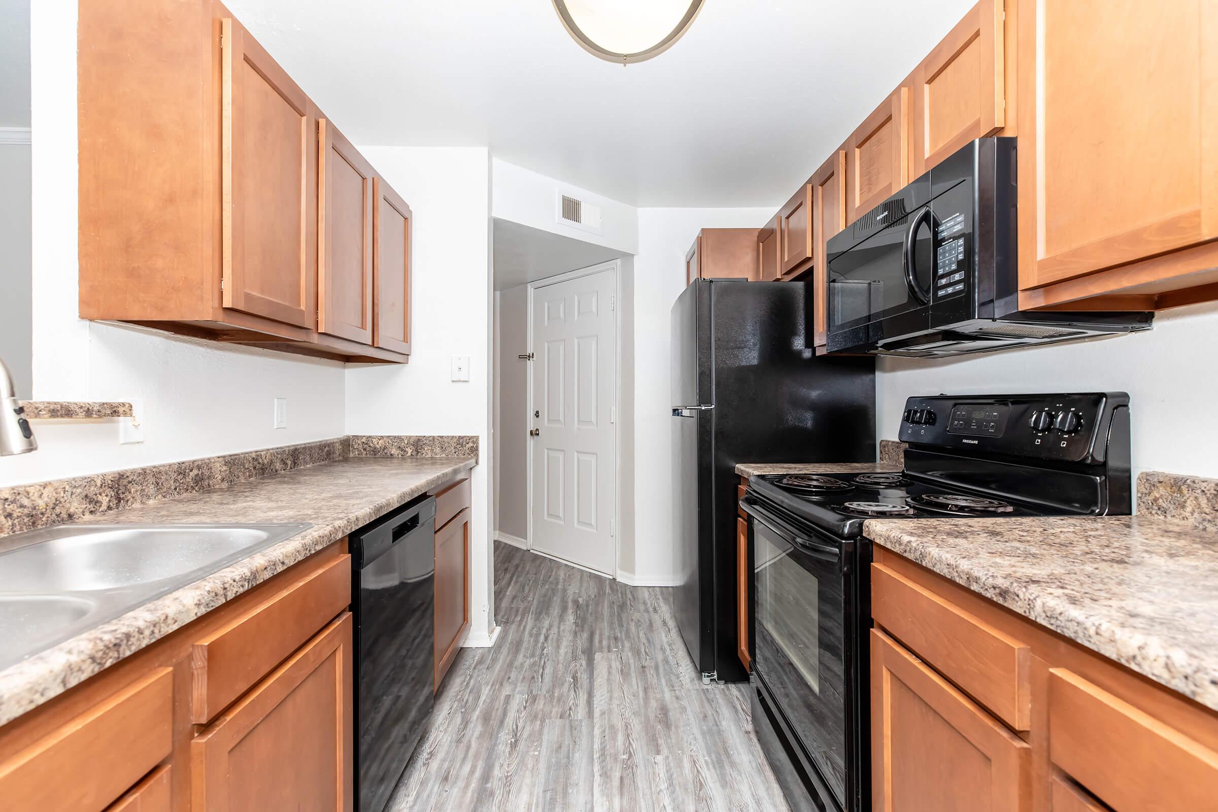 a modern kitchen with stainless steel appliances and wooden cabinets