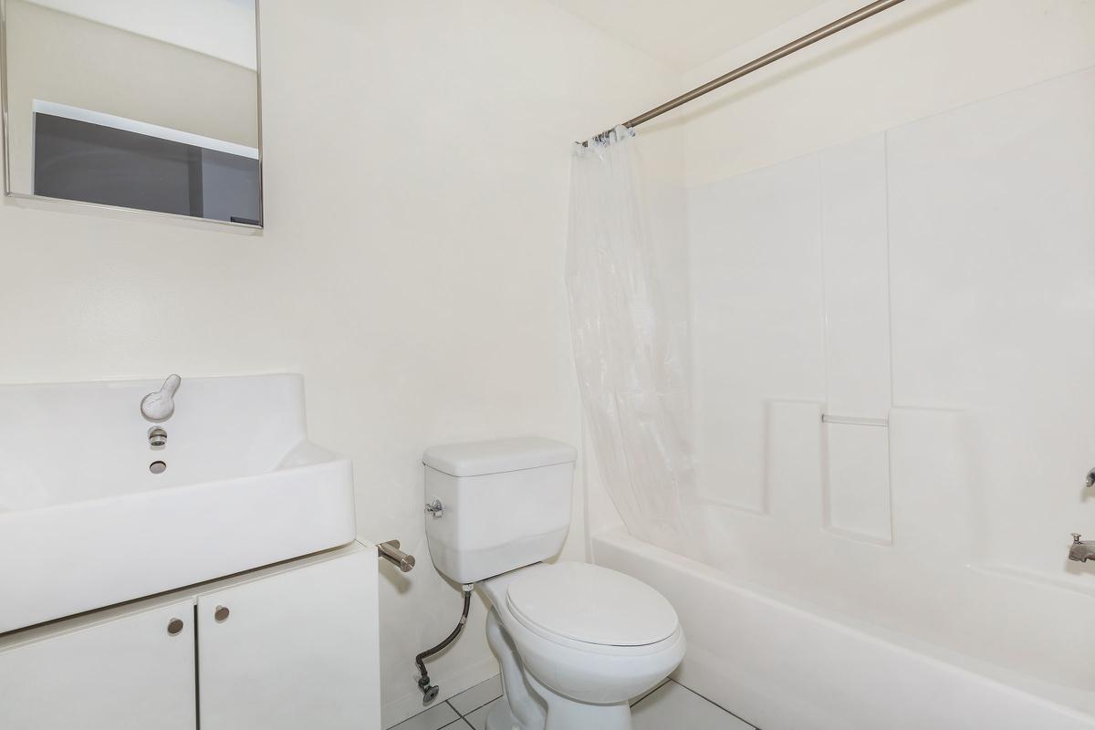 a white sink sitting next to a shower