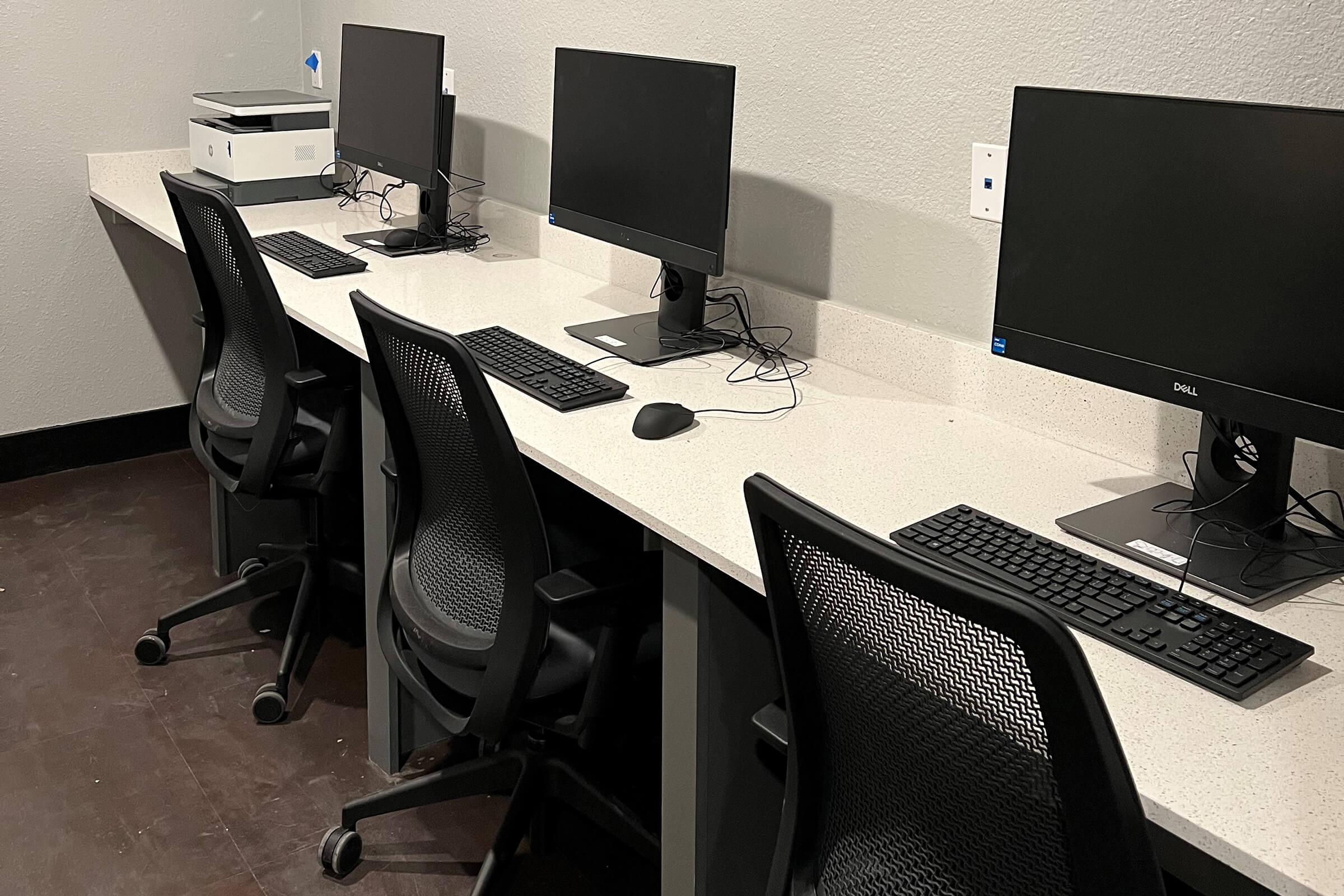 a desk with a laptop computer sitting on top of a chair