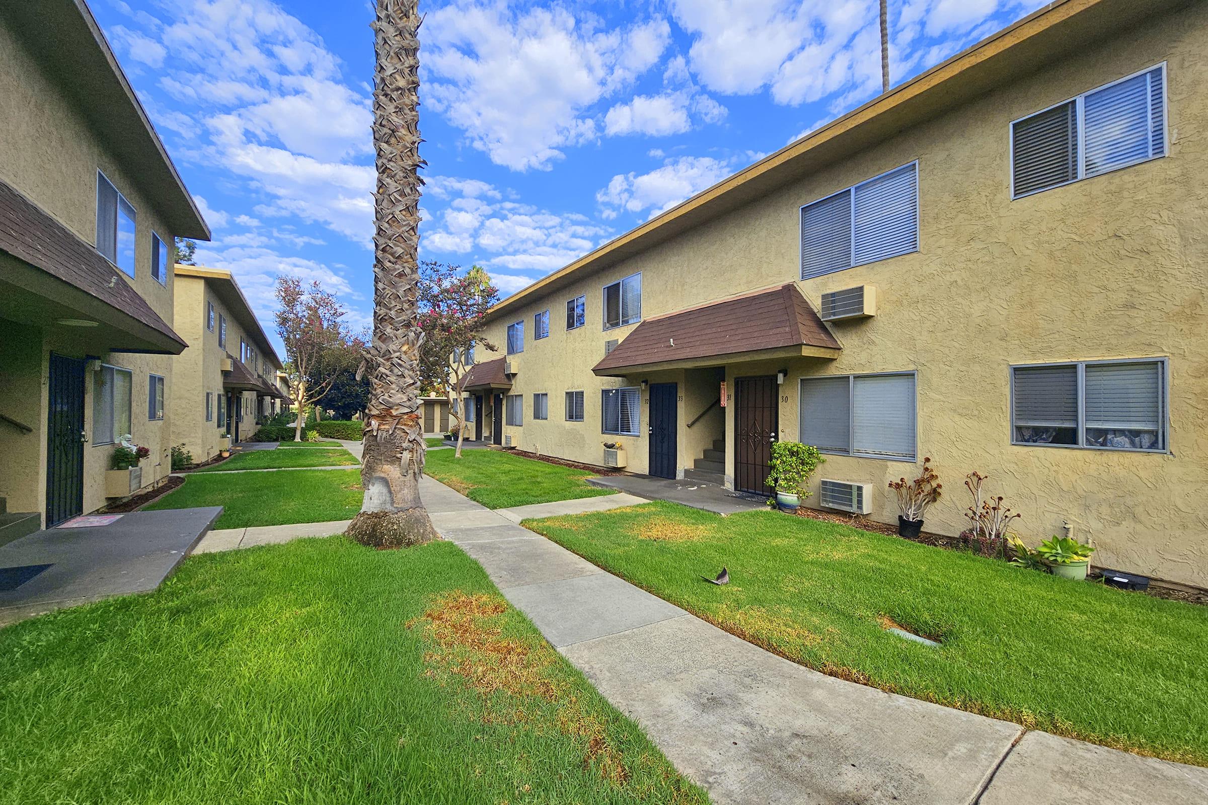 a large brick building with grass in front of a house