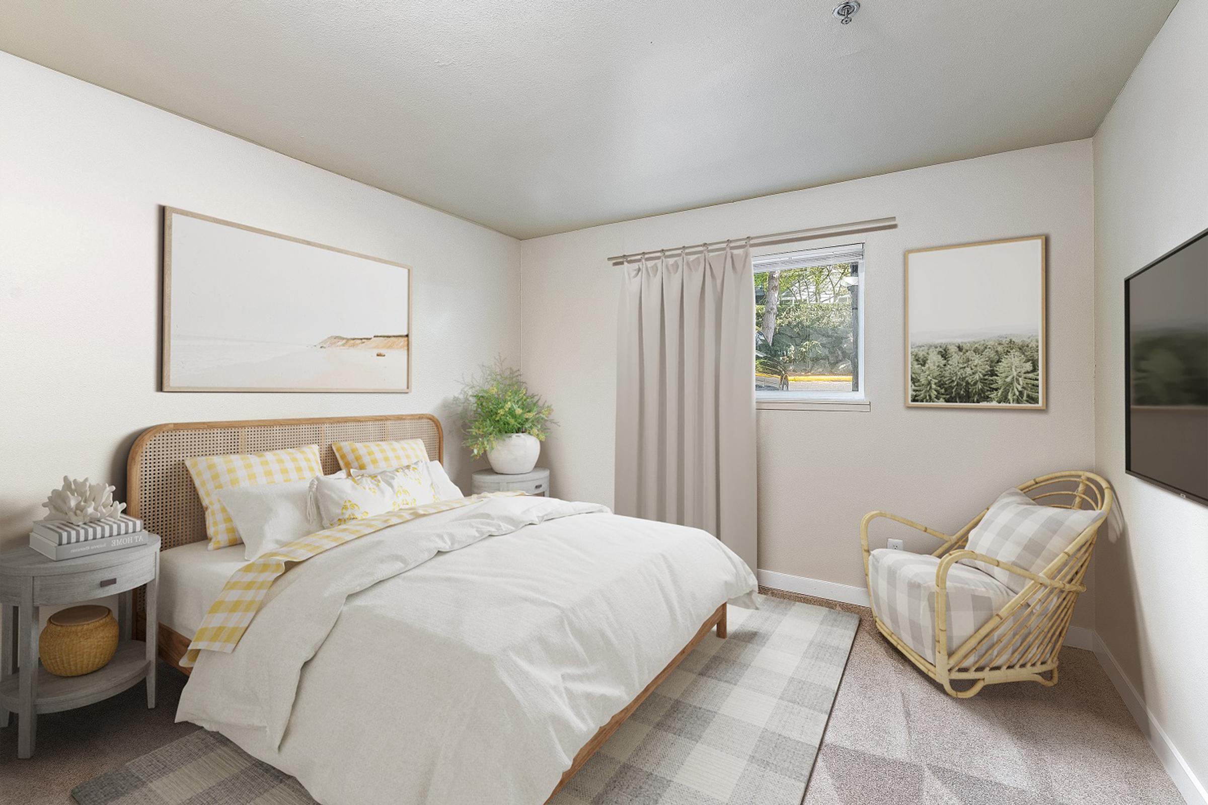A cozy bedroom featuring a queen-sized bed with light bedding and decorative pillows. There are two framed artworks on the walls, a window with light-colored curtains, and a rattan chair in the corner. The room has a neutral color palette with touches of greenery and soft textures, creating a warm and inviting atmosphere.