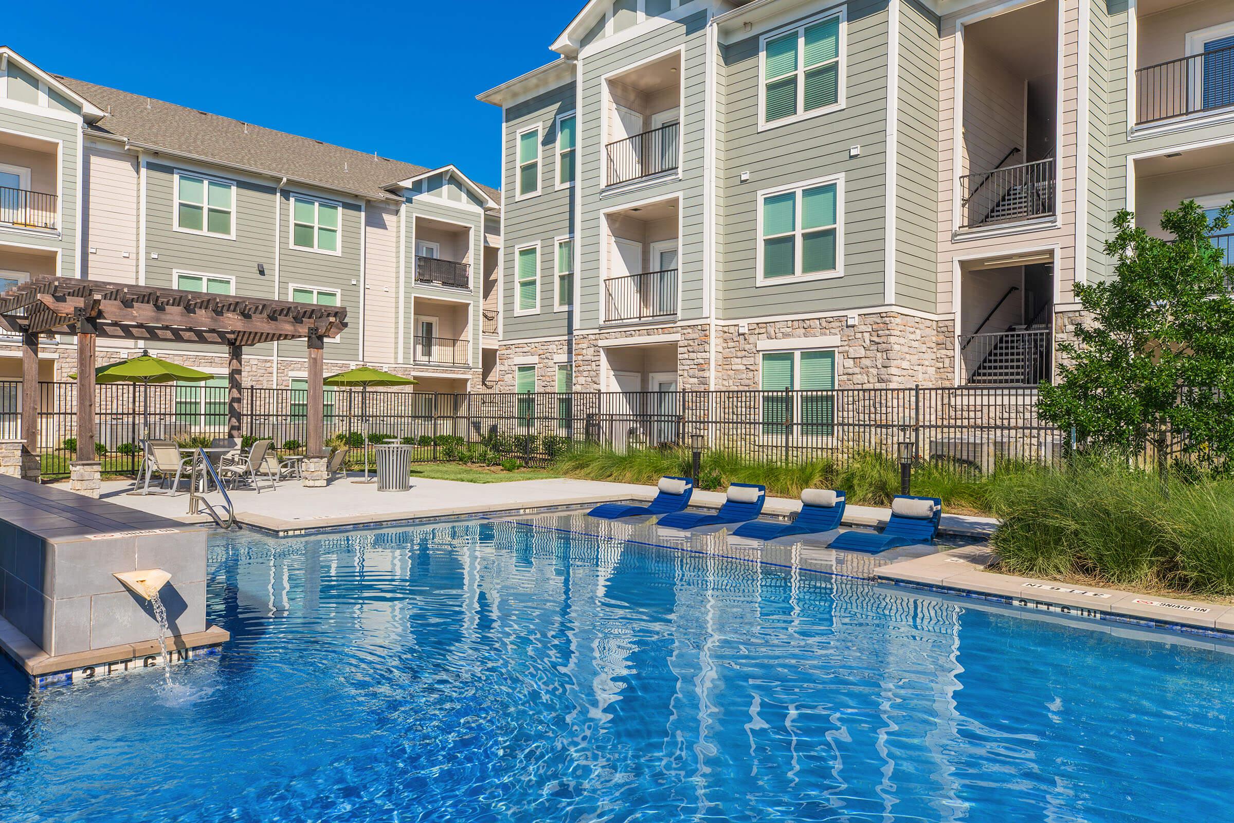 a flock of seagulls in a pool of water in front of a house