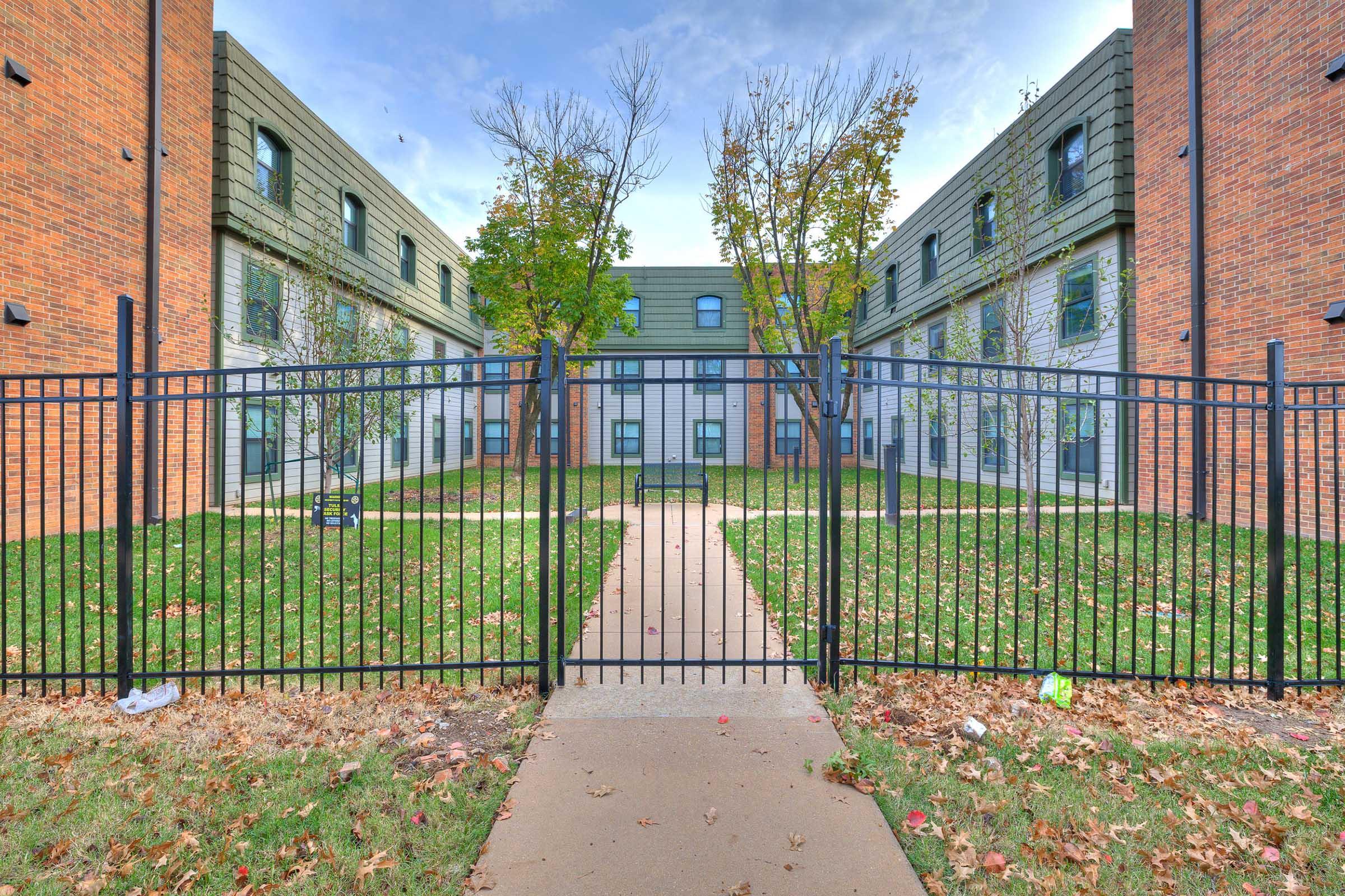 a gate in front of a brick building