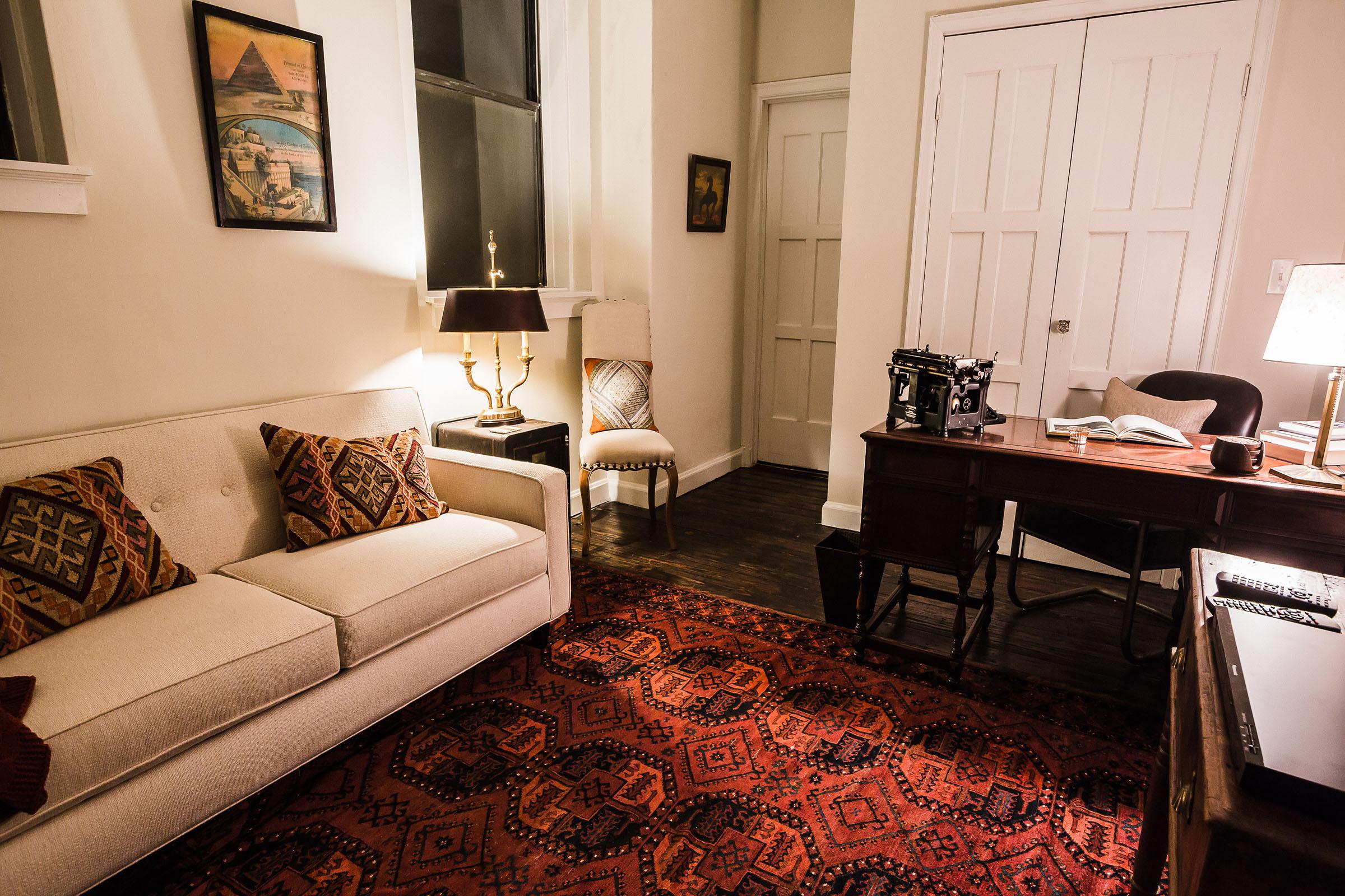 a living room with a bed and chair