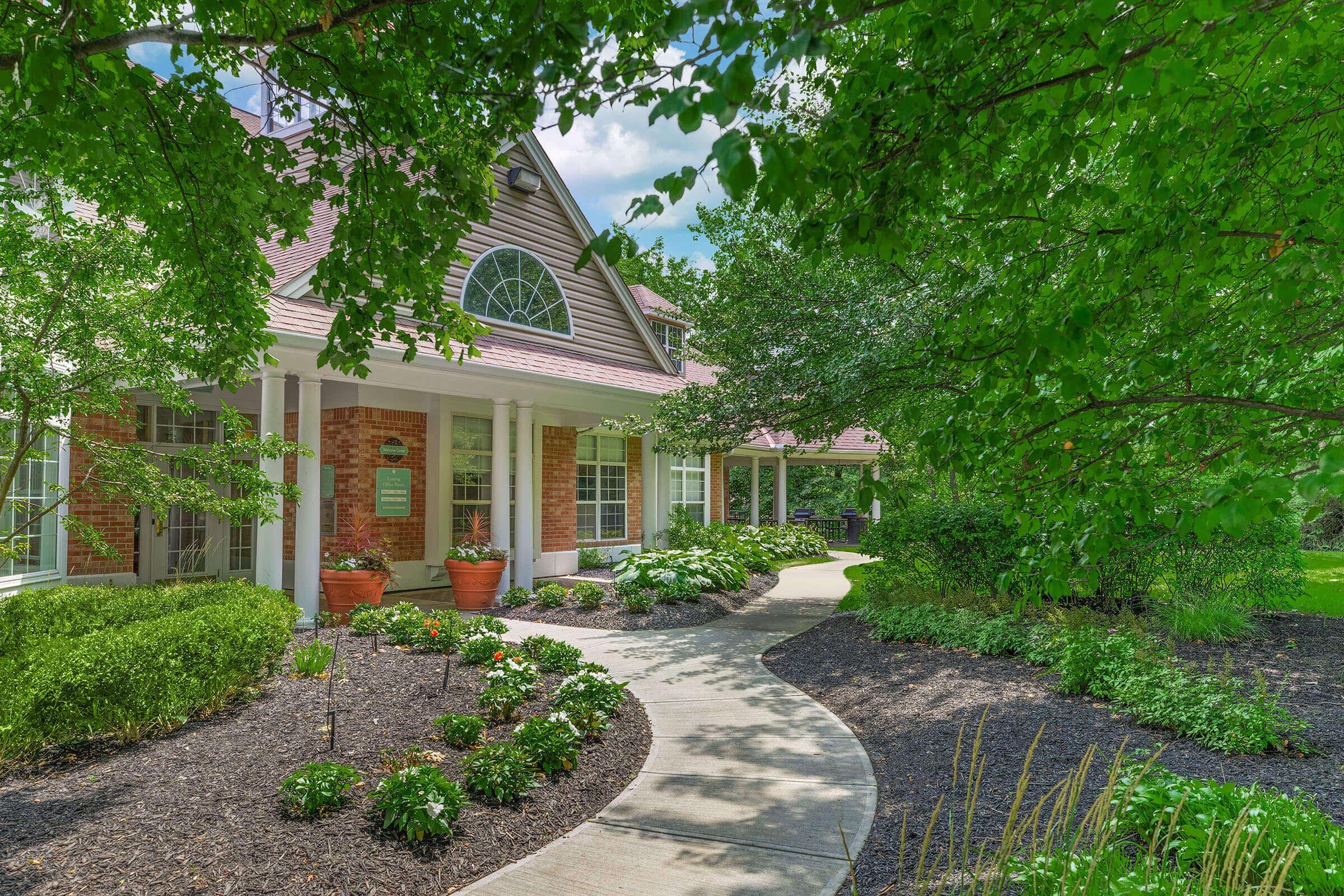 a house with bushes in front of a brick building