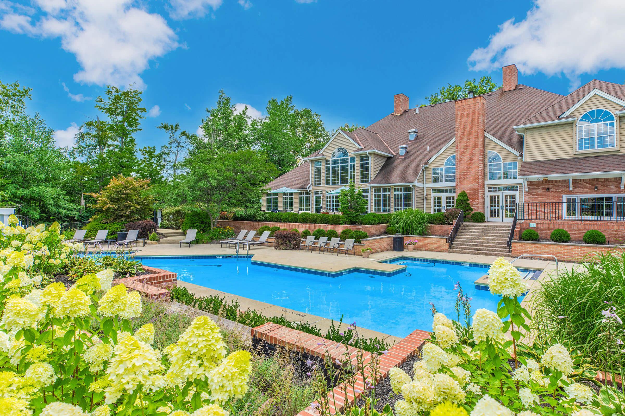 a garden with water in front of a house