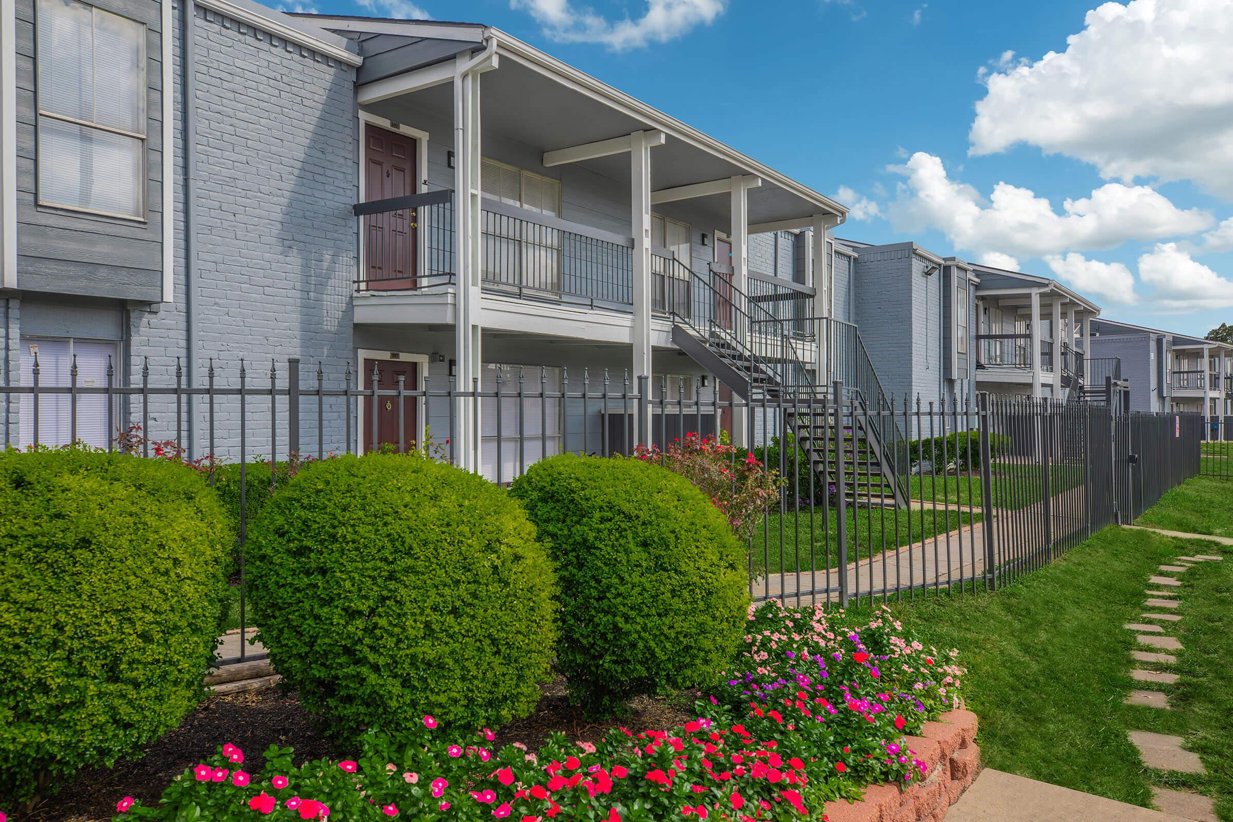 a close up of a flower garden in front of a building