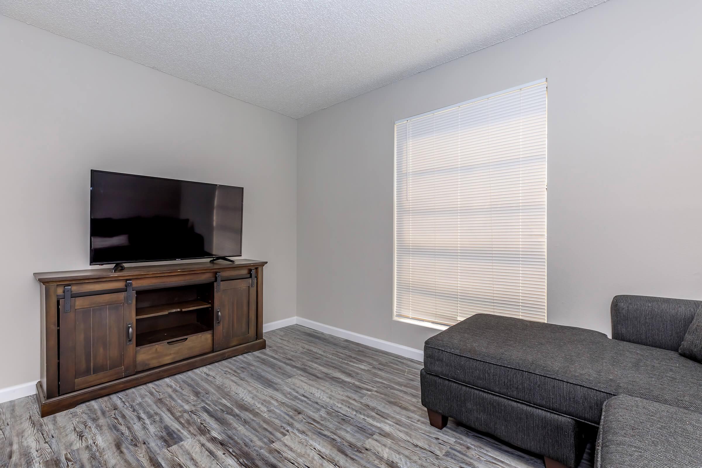 a living room filled with furniture and a flat screen tv