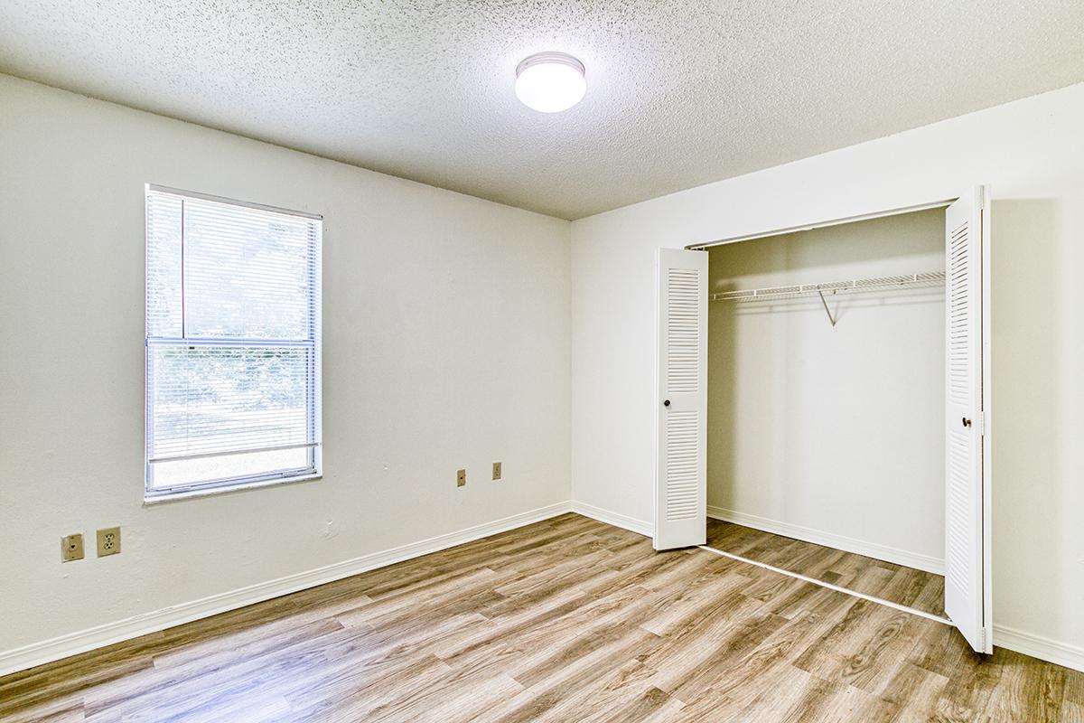 a bedroom with a bed and a mirror in a room