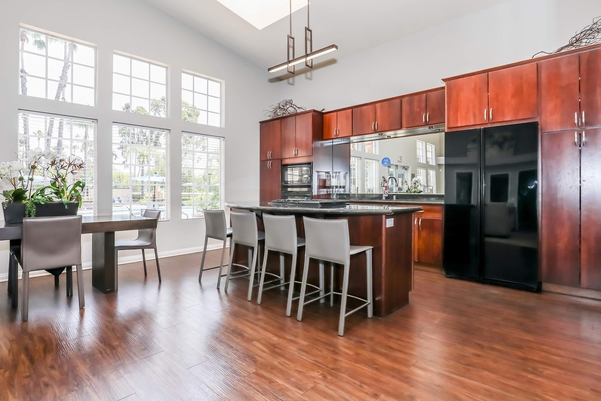 Pet-Friendly Apartments in Corona, CA - The Hills of Corona - Clubhouse with a Full Kitchen, Bar-Top Style Seating, and a Large Dining Table