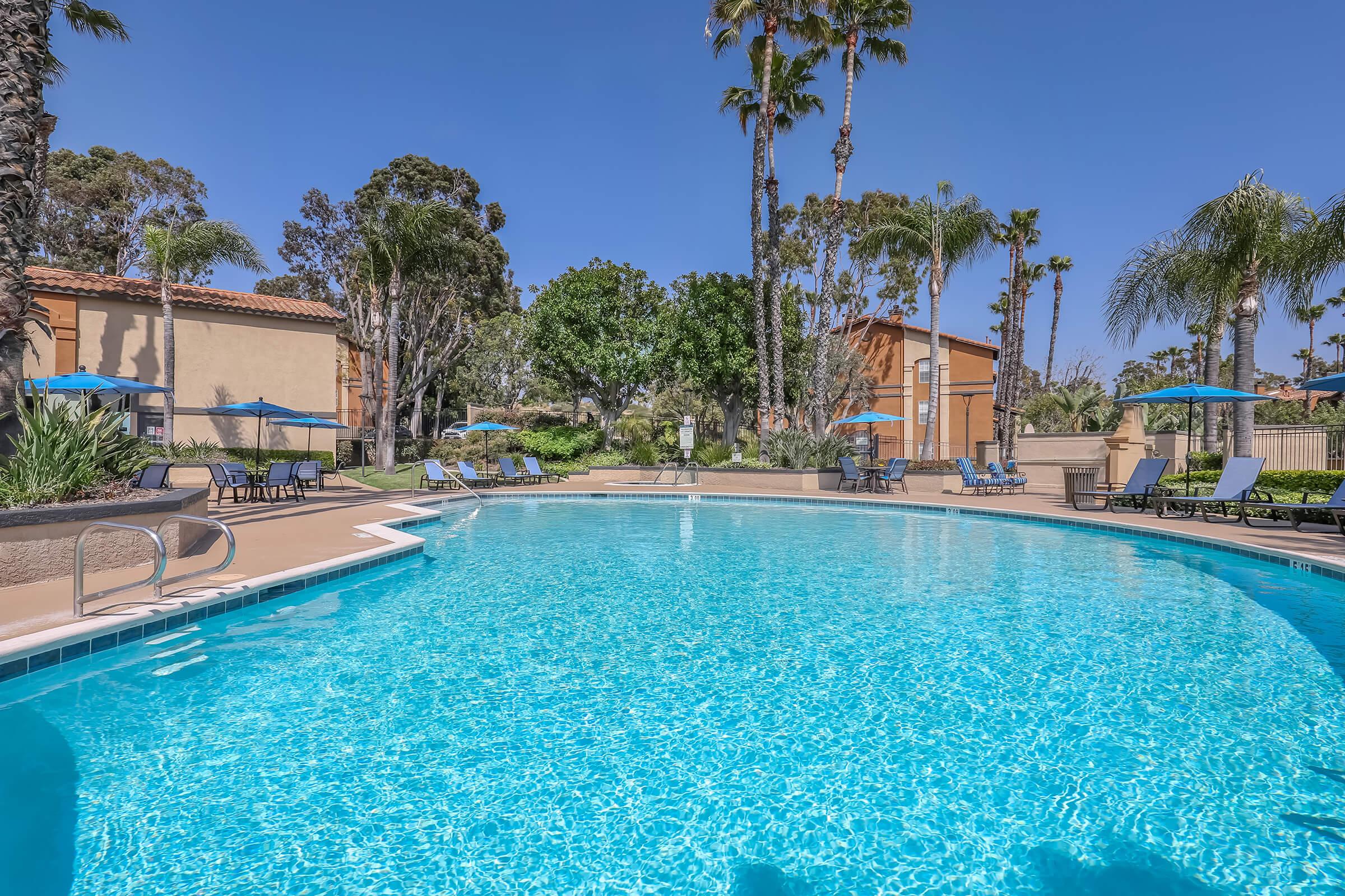 Two-Bedroom Apartments in Corona, CA - The Hills of Corona - Swimming Pool with Lounge Chairs, a Spa, and Lush Landscaping