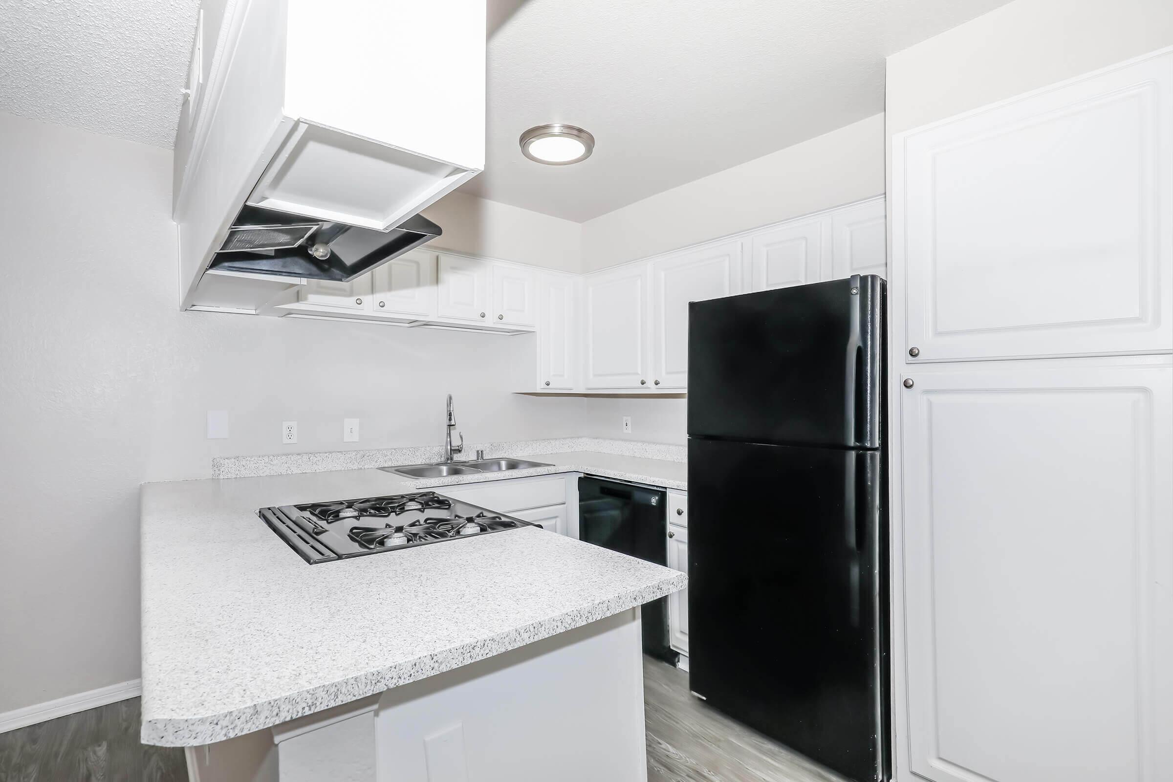 2-Bedroom Apartments in Corona, CA - The Hills of Corona - Kitchen with a Breakfast Bar, Modern Appliances, and a Gas Stove