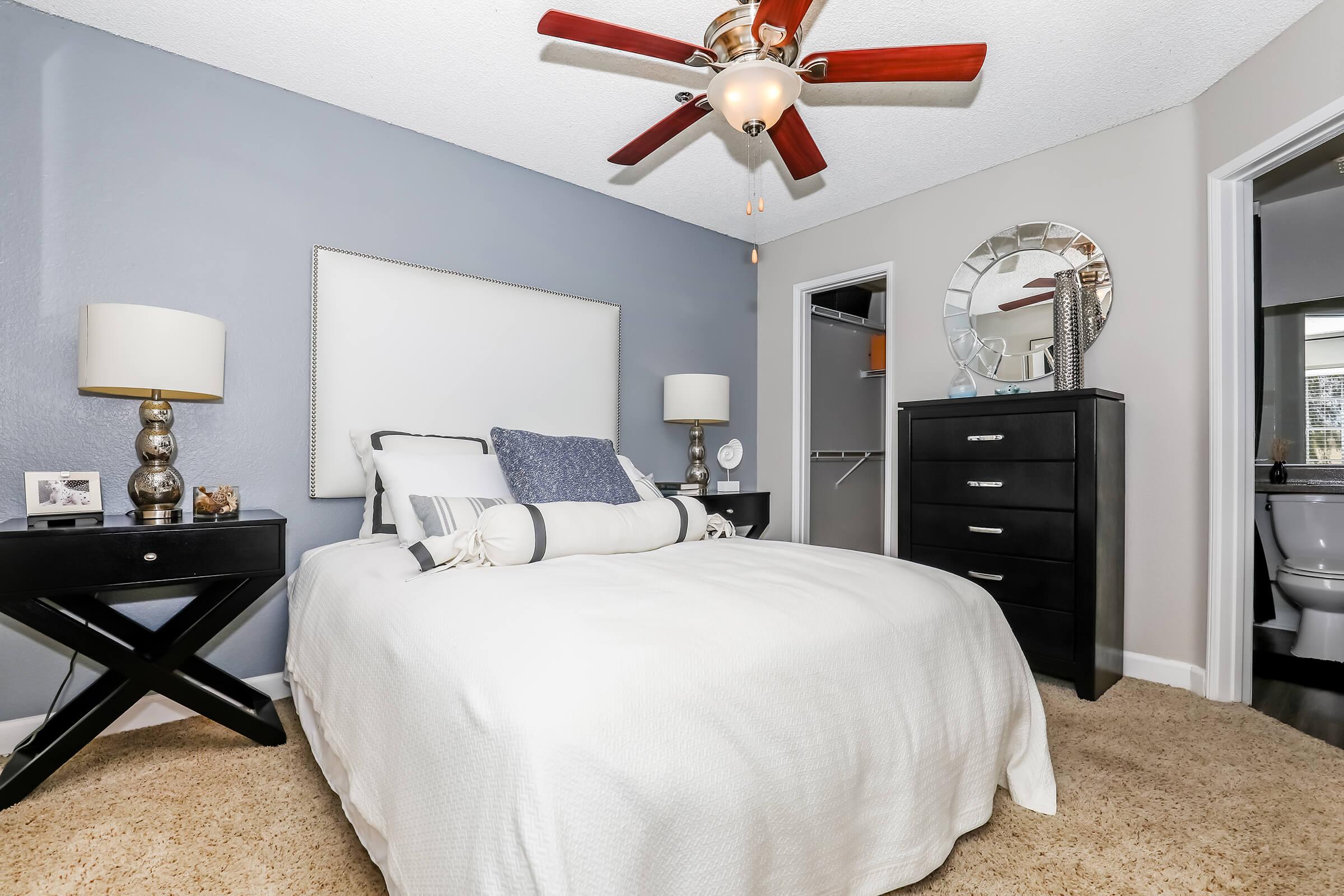 a bedroom with a bed and desk in a hotel room