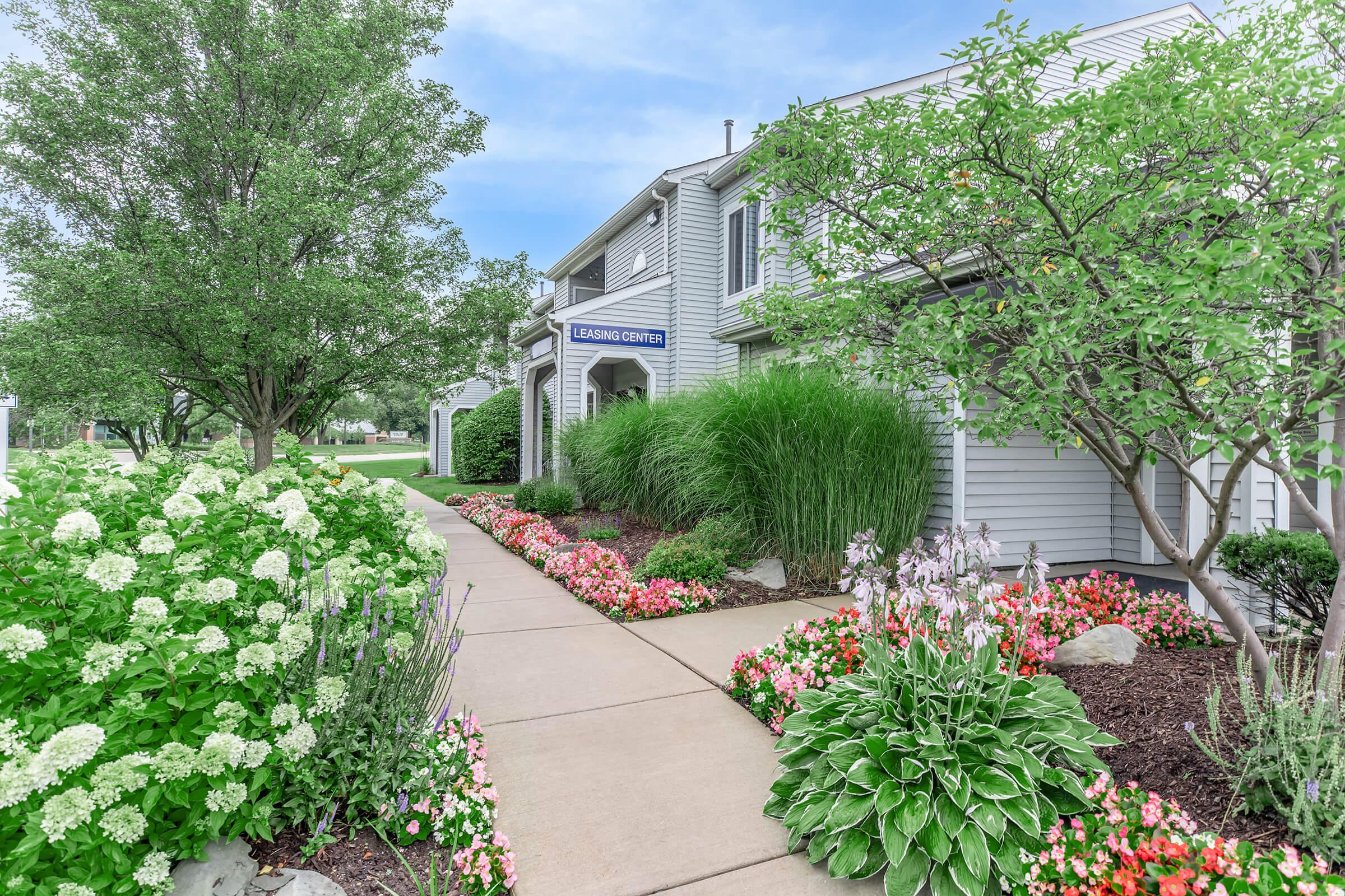 a close up of a flower garden in front of a house